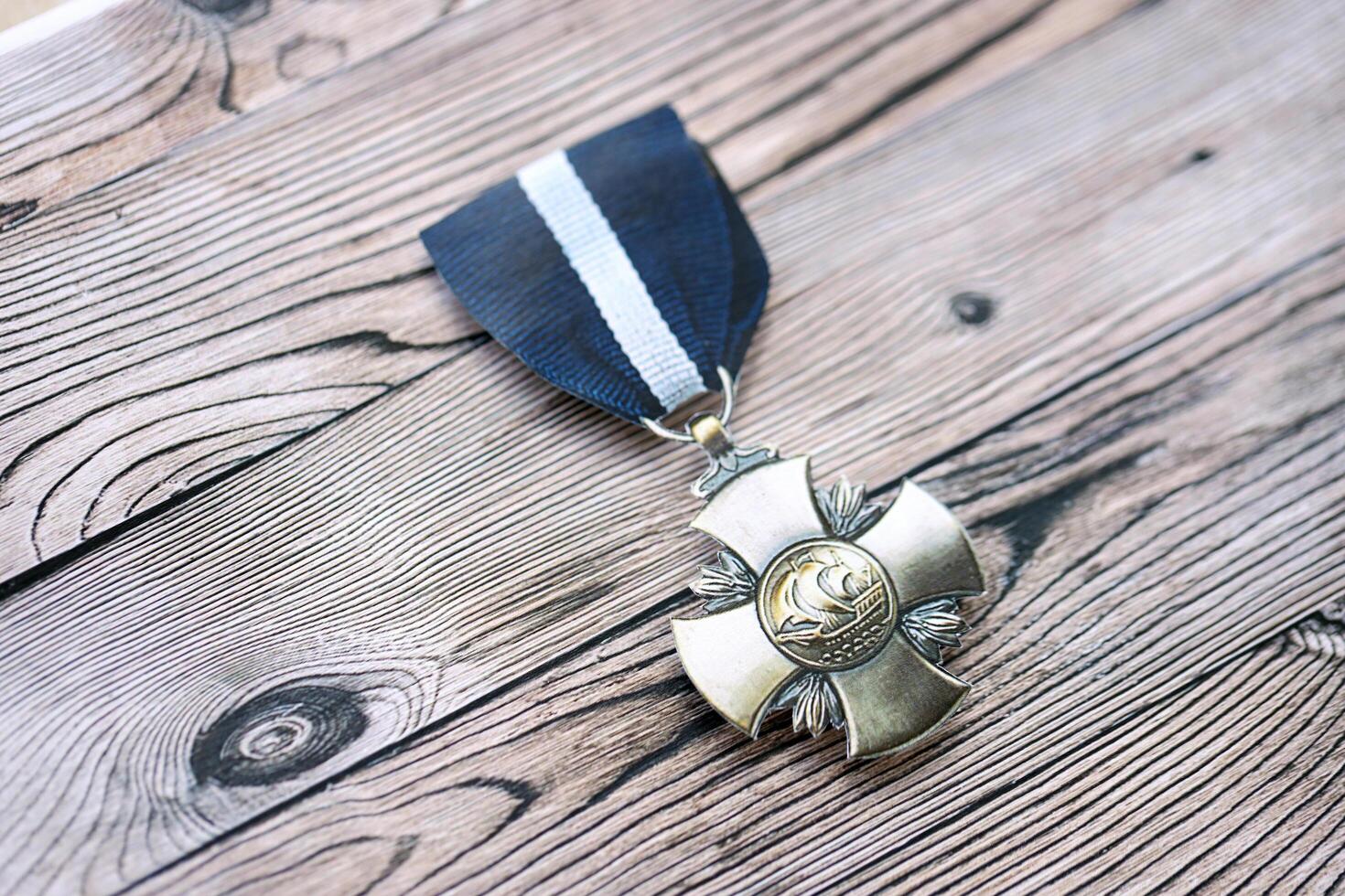 KYIV, UKRAINE - JULY 10, 2024 US Navy Cross medal. United States military award medal with ribbon and pin. Handmade paper theater props photo