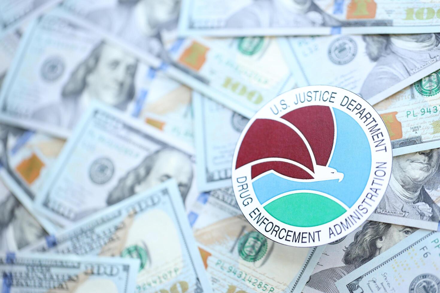 KYIV, UKRAINE - JUNE 26, 2024 U.S. Justice Department Drug Enforcement Administration coat of arms on big amount of US dollar banknotes photo