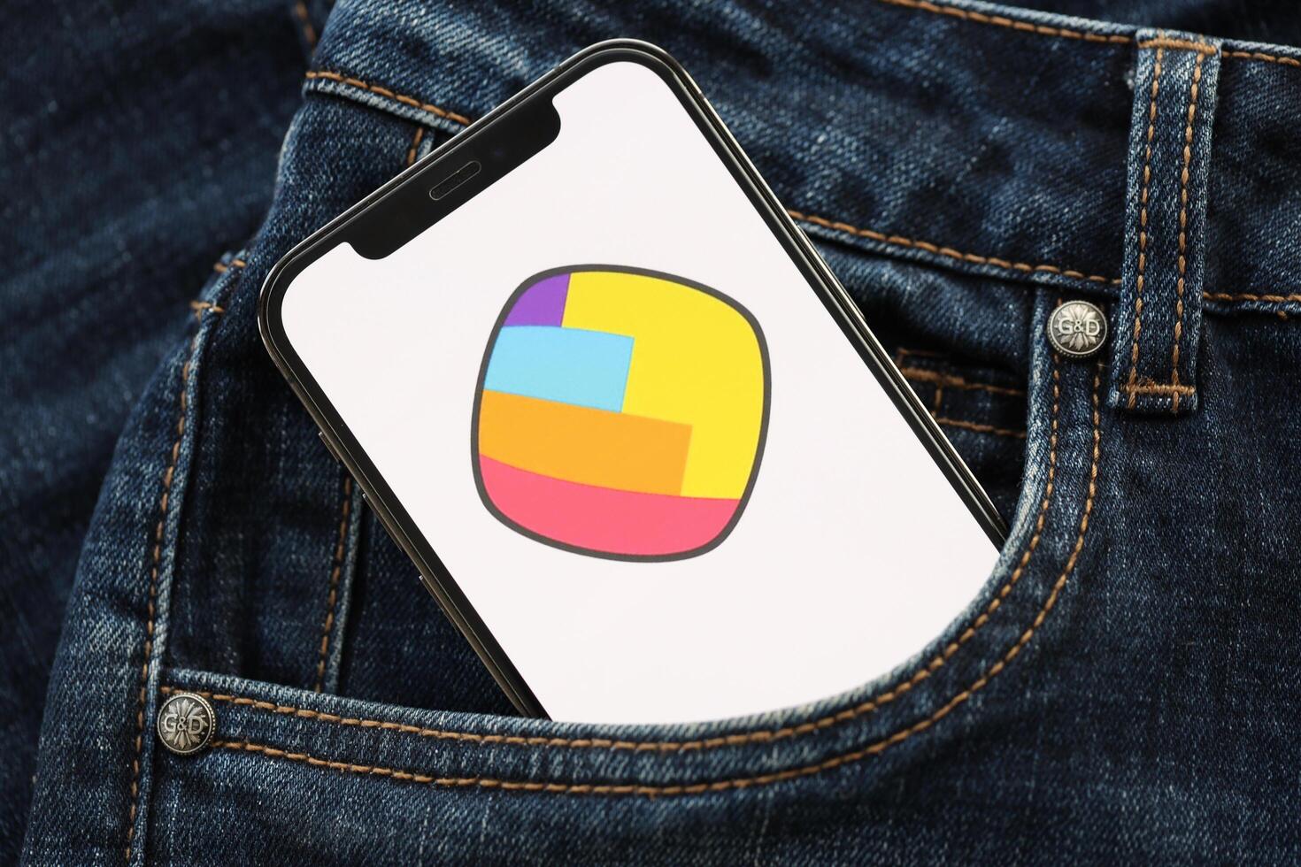KYIV, UKRAINE - APRIL 1, 2024 Sharechat icon on smartphone display screen in jeans pocket photo