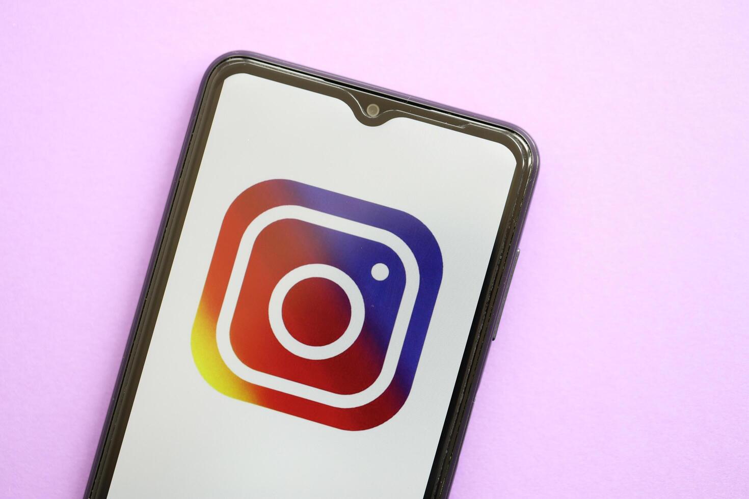 KYIV, UKRAINE - APRIL 1, 2024 Instagram icon on smartphone screen on purple table photo