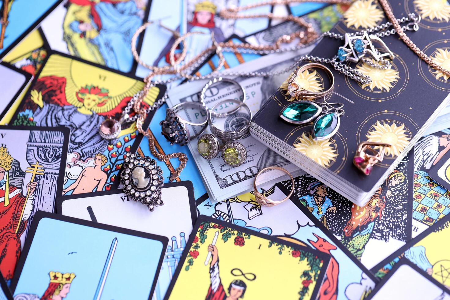 KYIV, UKRAINE - JULY 10, 2024 Tarot minor and major arcana cards of Rider Waite esoteric deck and golden rings and necklace chains. Many tarot cards for fortune telling and expensive items photo