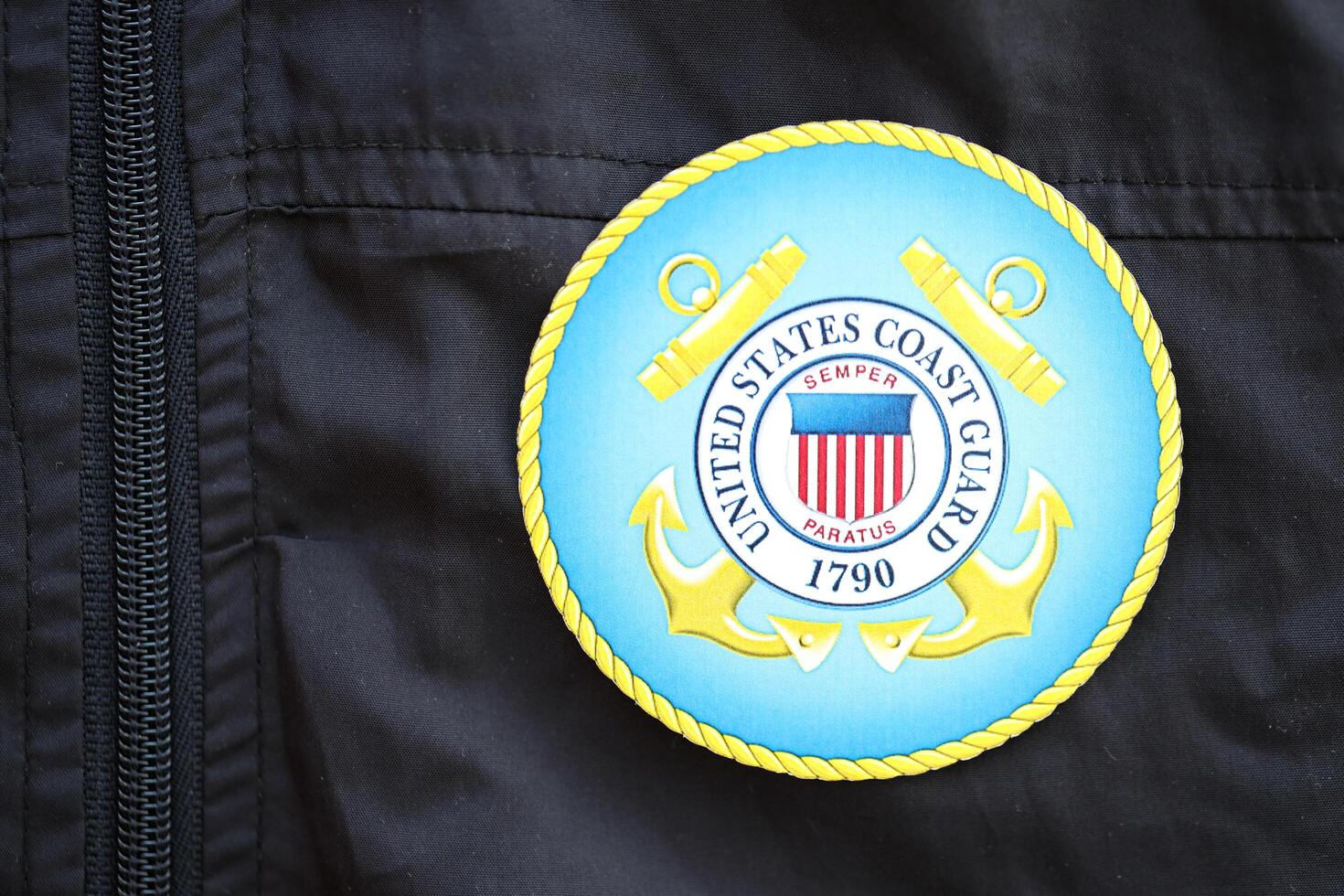 KYIV, UKRAINE - JUNE 26, 2024 United States Coast Guard coat of arms as pin on black uniform jacket photo