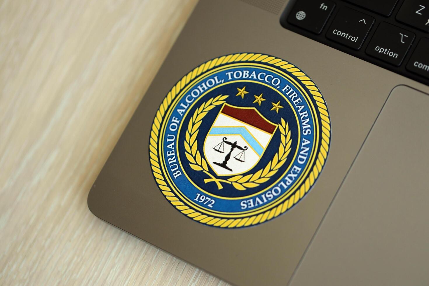 KYIV, UKRAINE - JUNE 26, 2024 Bureau of Alcohol, Tobacco, Firearms and Explosives coat of arms sticker on silver laptop photo