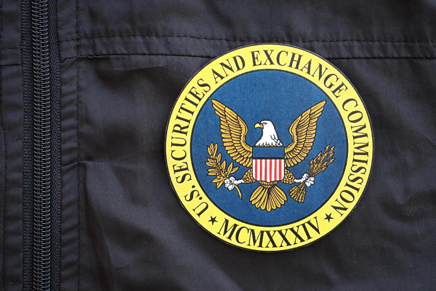 KYIV, UKRAINE - JUNE 26, 2024 U.S. Securities and Exchange Commission coat of arms as pin on black uniform jacket photo