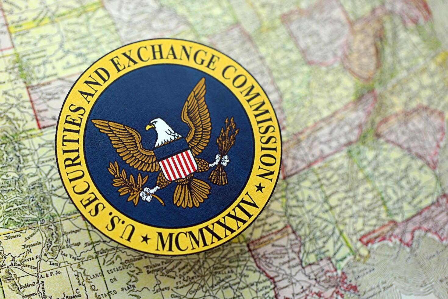 KYIV, UKRAINE - JUNE 26, 2024 U.S. Securities and Exchange Commission coat of arms on paper map of United States photo