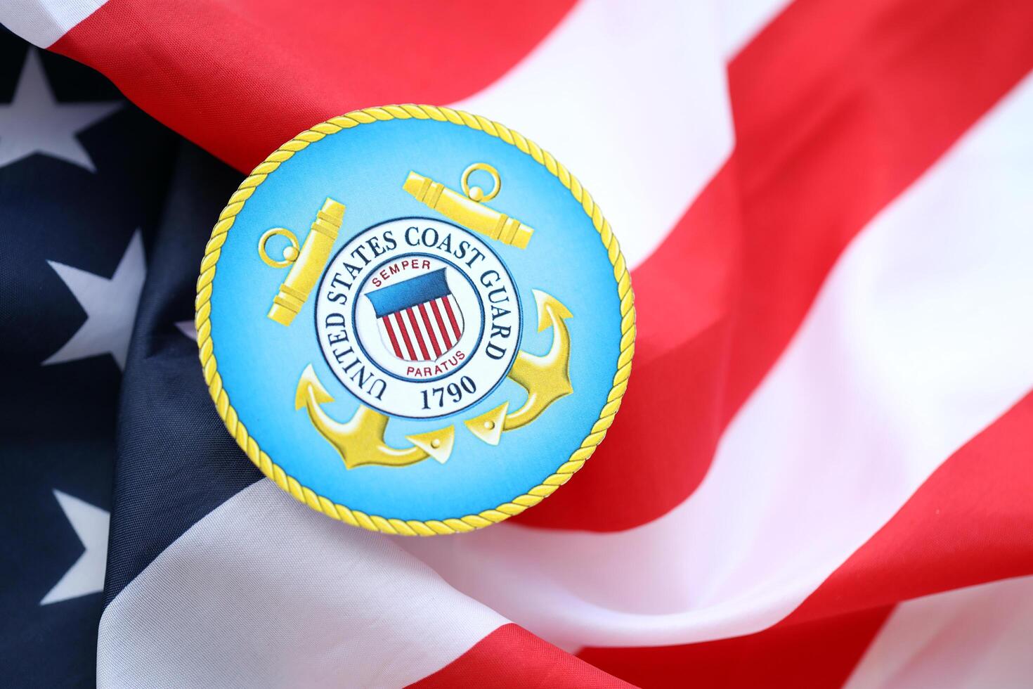 KYIV, UKRAINE - JUNE 26, 2024 United States Coast Guard coat of arms sticker on folded US flag photo