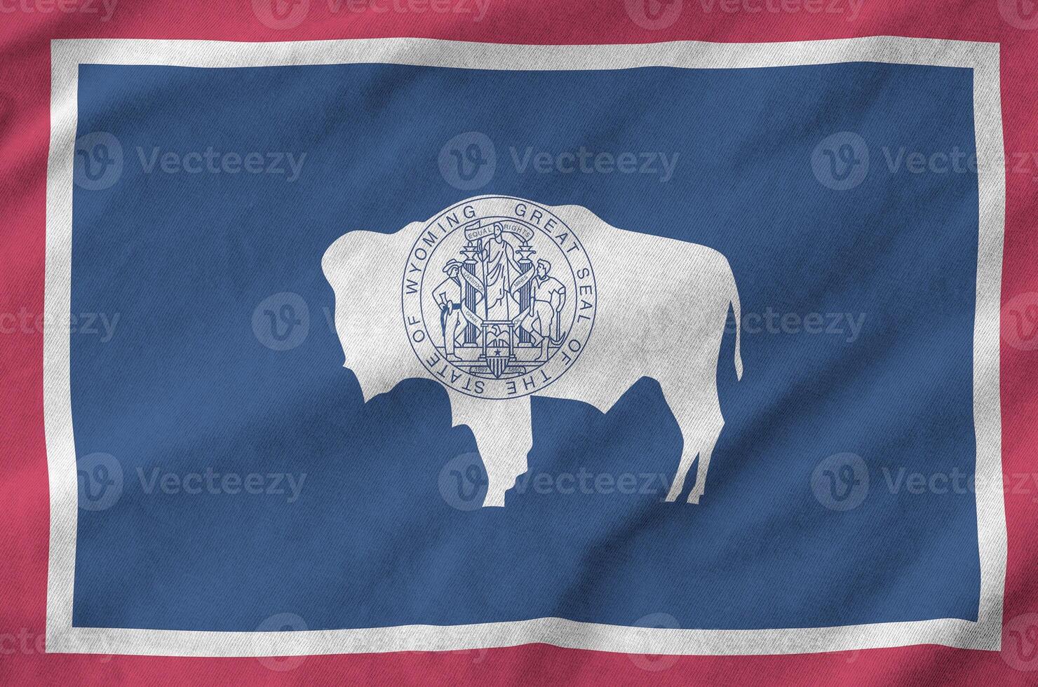 Wyoming US state flag depicted on folded wavy fabric of old cloth photo