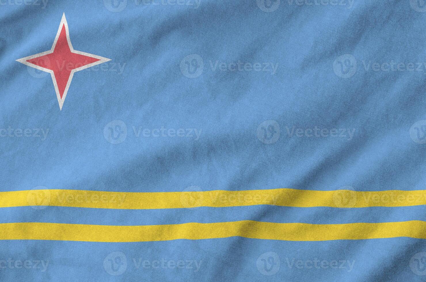 Aruba flag depicted on folded wavy fabric of old cloth photo