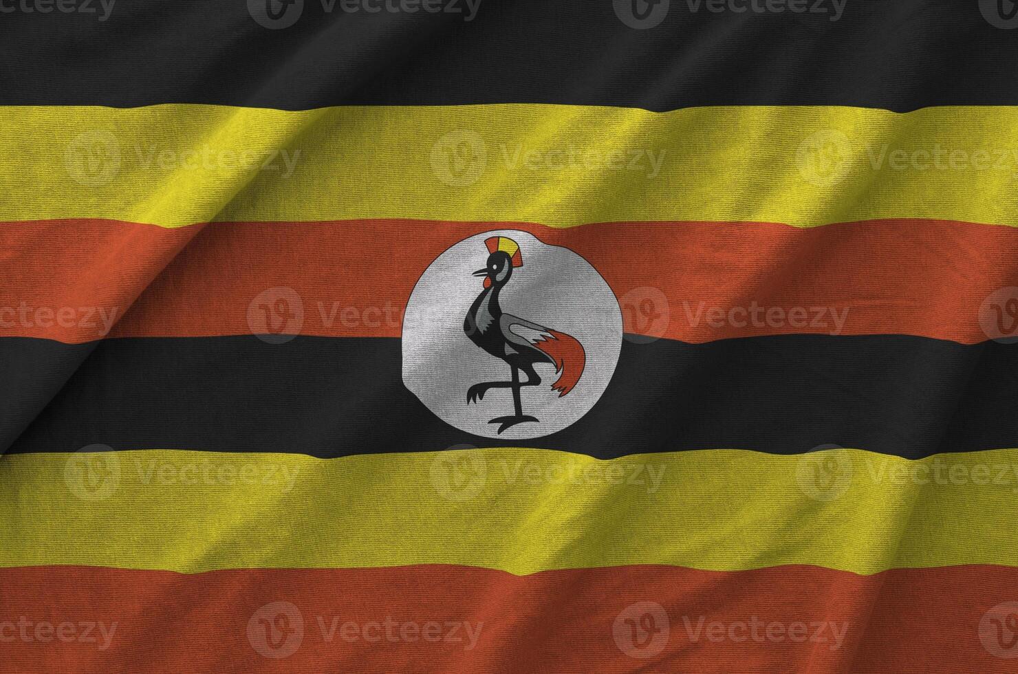 Uganda flag depicted on folded wavy fabric of old cloth photo