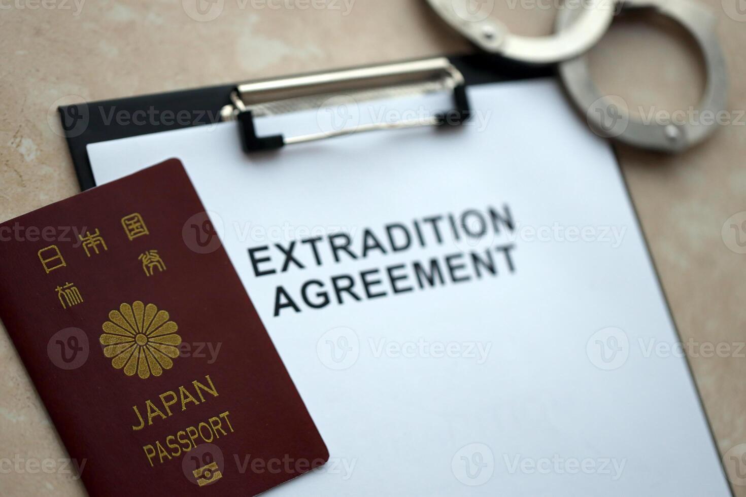 Passport of Japan and Extradition Agreement with handcuffs on table photo
