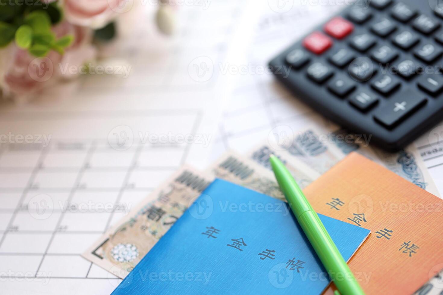 Japanese pension insurance booklets on table with yen money bills and calculator on table photo