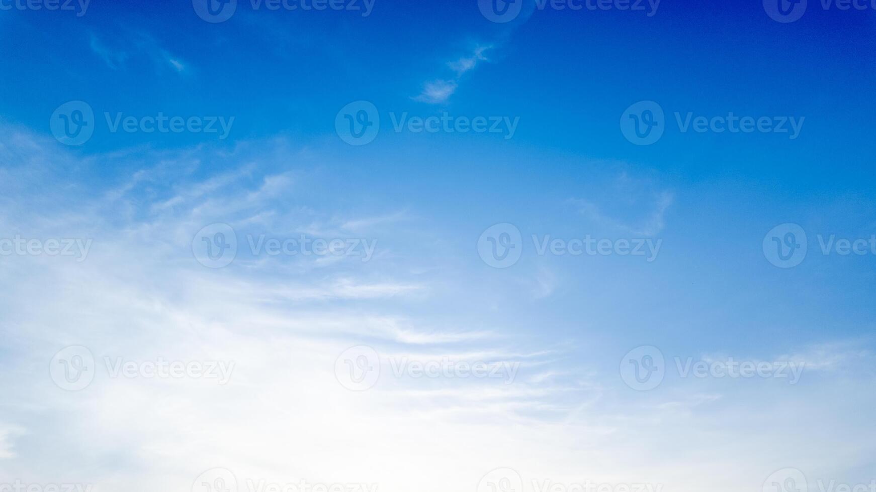 Clear blue sky with soft white clouds symbolizing tranquility, perfect for spring or summer backgrounds, and nature related concepts photo