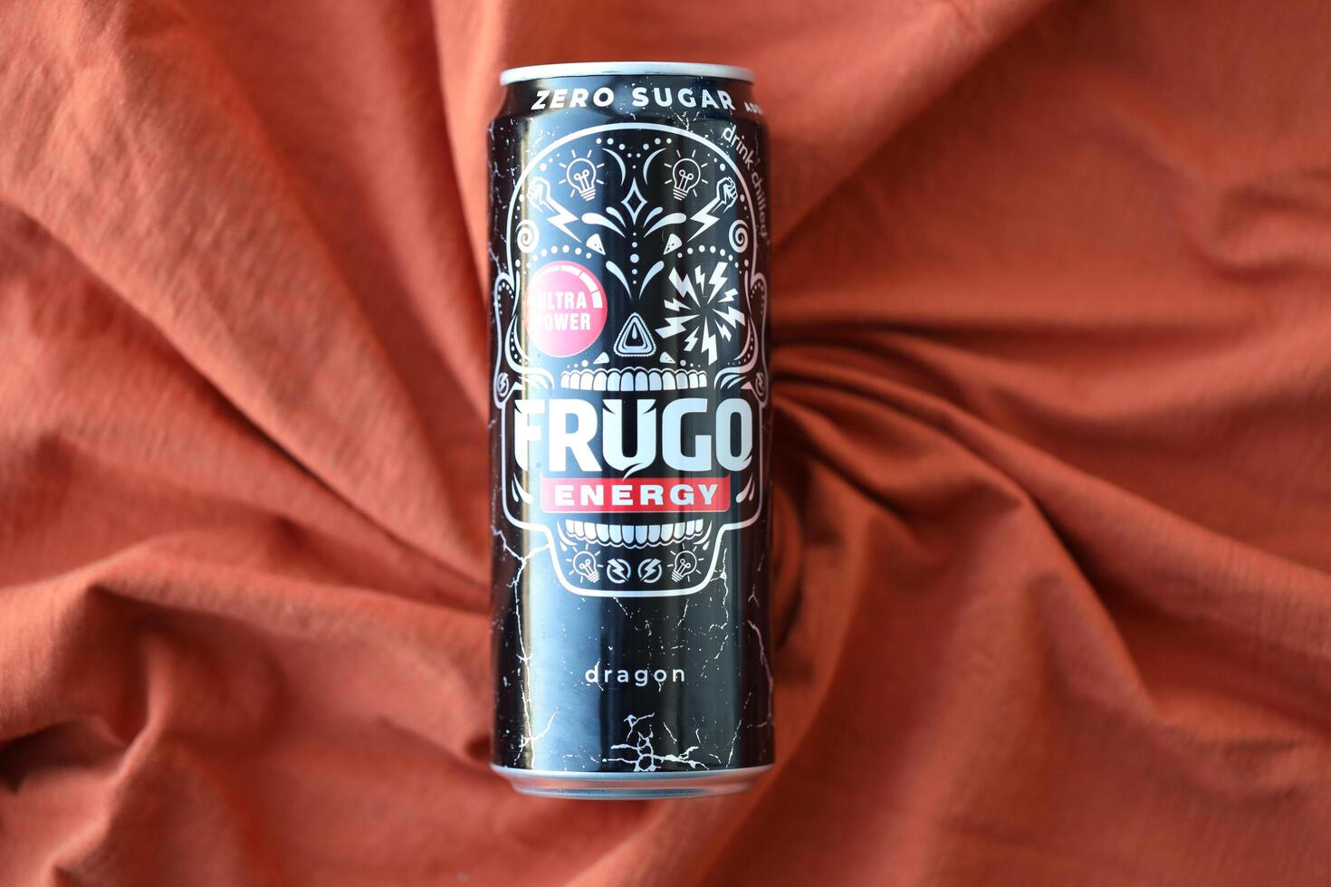 KYIV, UKRAINE - APRIL 20, 2024 Frugo energy drink in black can on orange fabric. Frugo is now owned by Food Care Poland photo