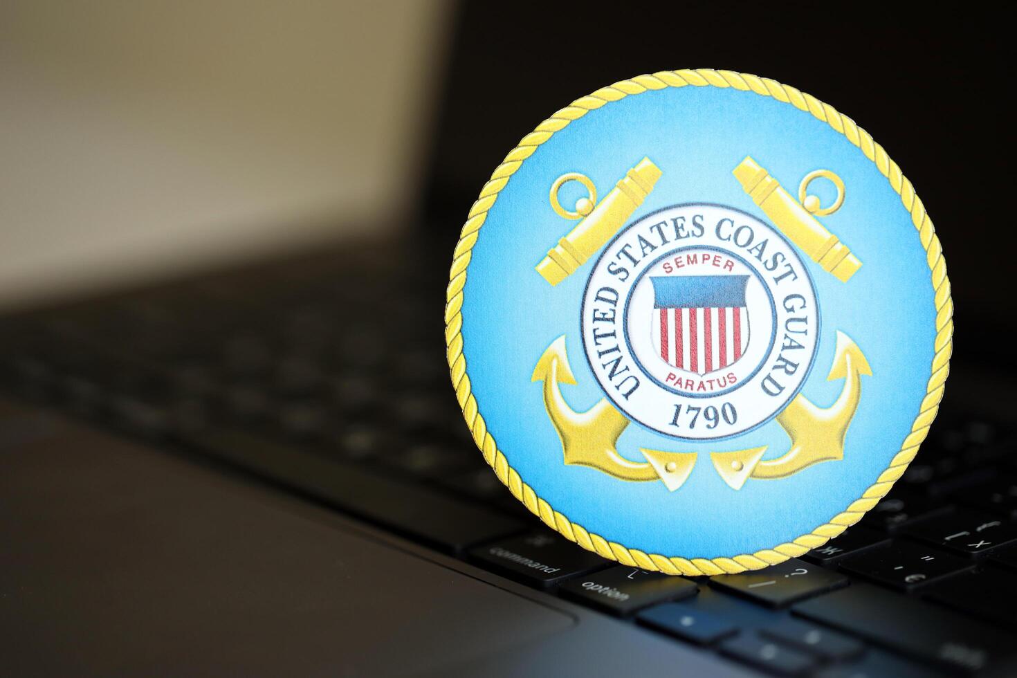 KYIV, UKRAINE - JUNE 26, 2024 United States Coast Guard coat of arms sticker on silver laptop photo