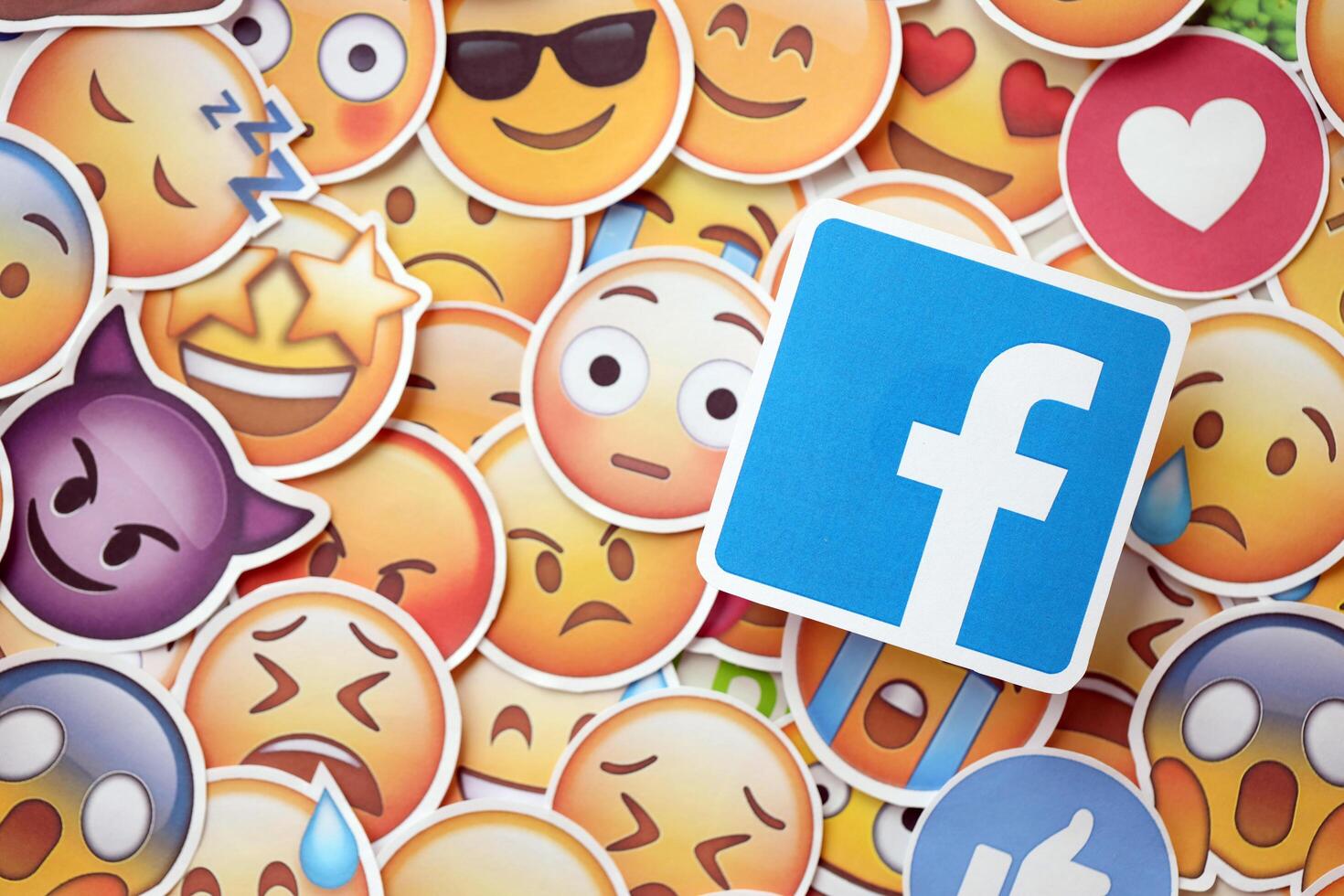 KYIV, UKRAINE - APRIL 20, 2024 Facebook logo and large set of stickers with Emoji yellow faces. Emoji is a pictogram or smiley embedded in text and used in electronic messages photo