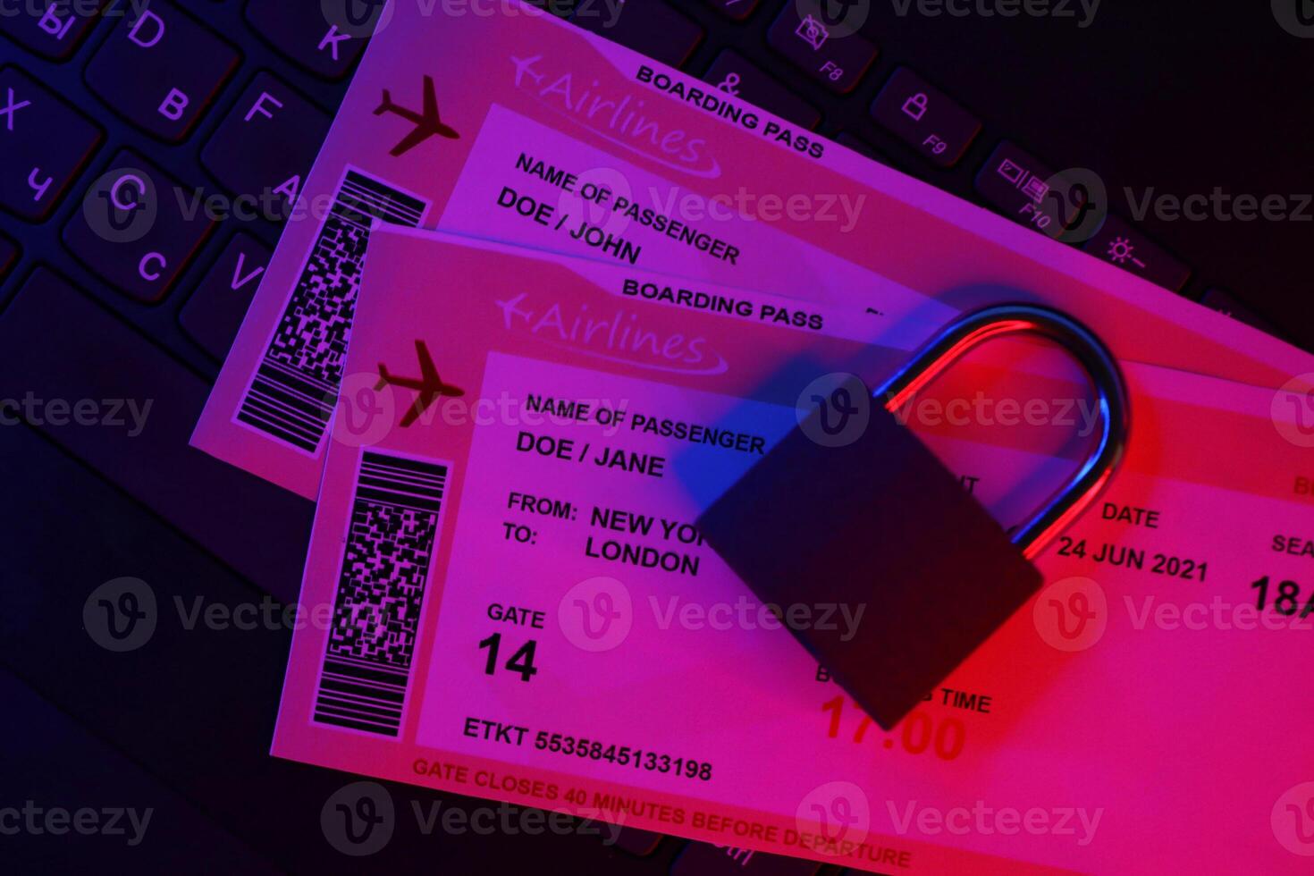 Fictional air tickets and small padlock on computer keyboard photo