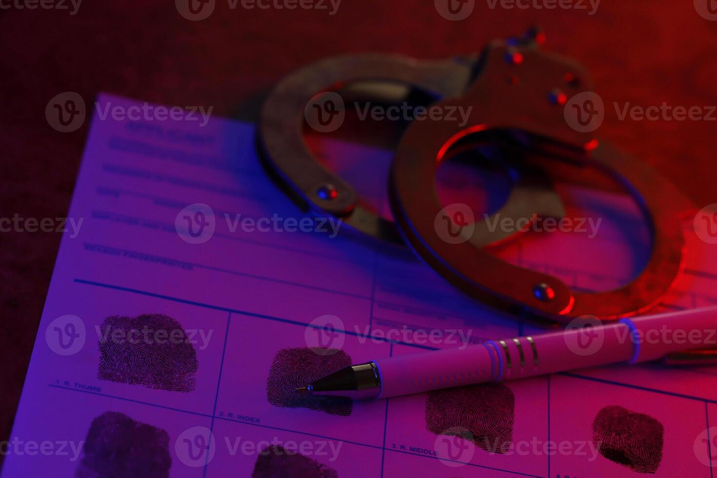 Applicant or fingerprints card with police handcuffs on table in dark room photo