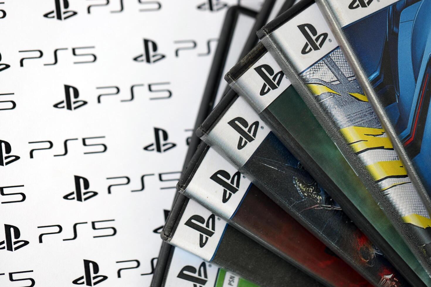 KYIV, UKRAINE - JUNE 26, 2024 Stack of games for Sony Playstation 5 and 4 console. Many disc boxes of popular games photo