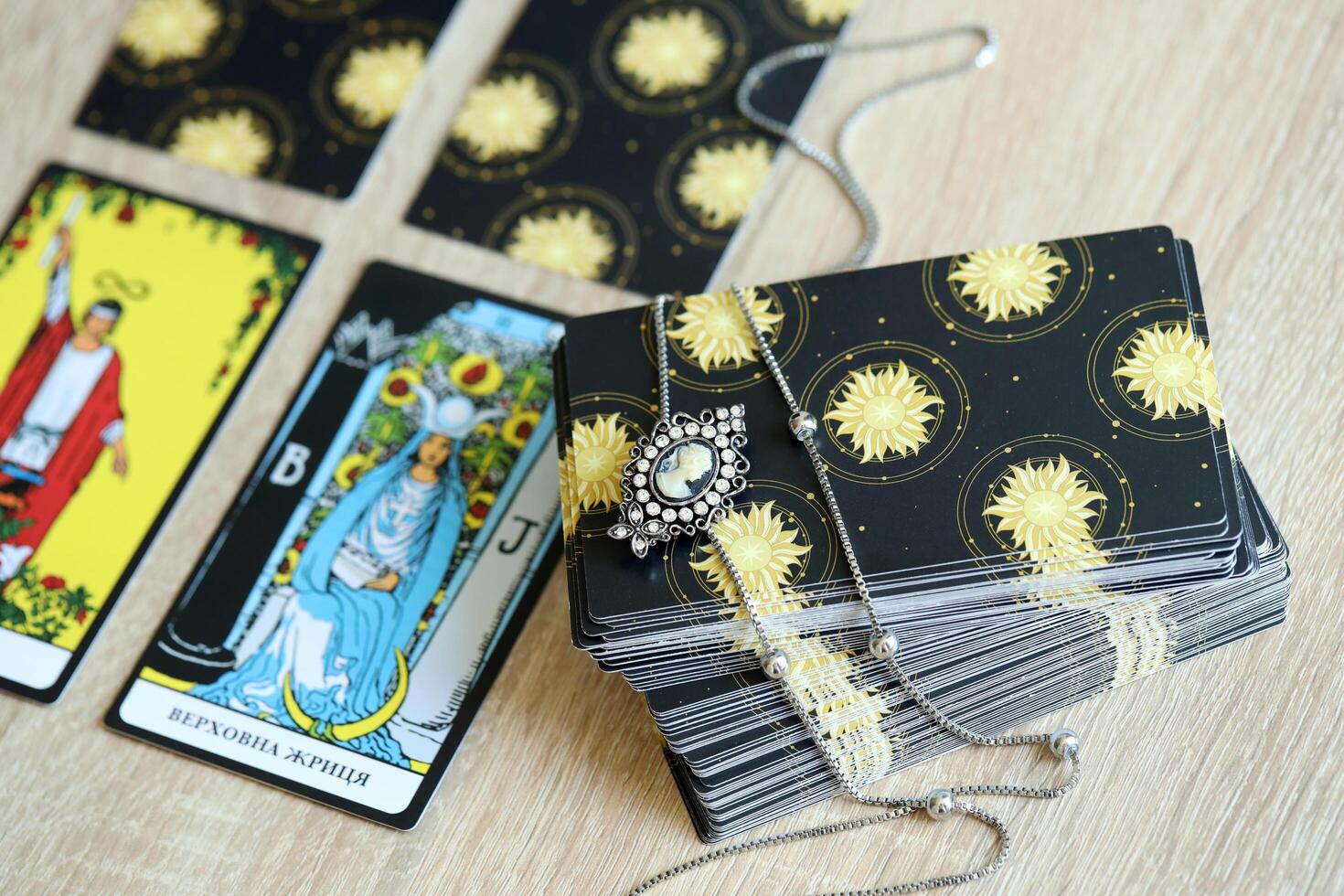KYIV, UKRAINE - JULY 10, 2024 Tarot minor and major arcana cards of Rider Waite esoteric deck and vintage brooch with female silhouette. Many tarot cards for fortune telling and old amulet photo
