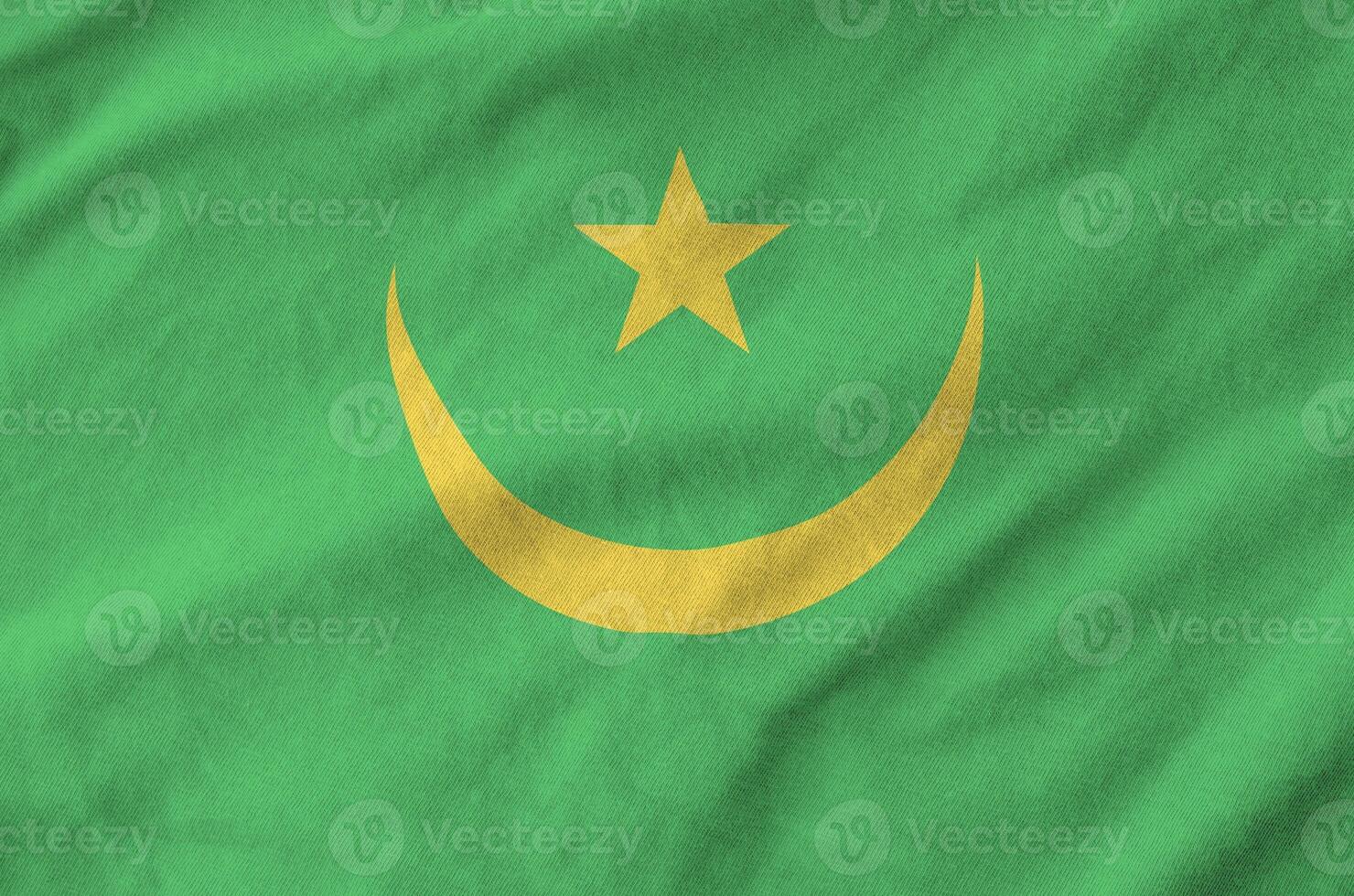 Mauritania flag depicted on folded wavy fabric of old cloth photo