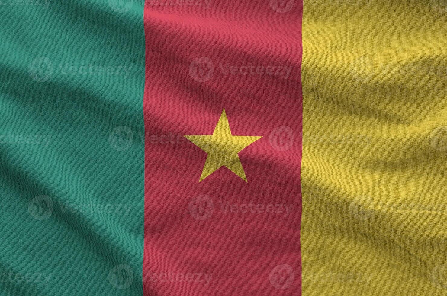 Cameroon flag depicted on folded wavy fabric of old cloth photo