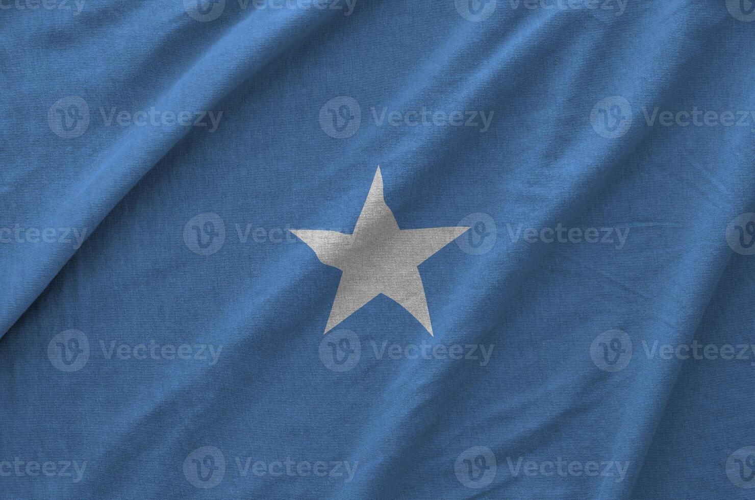 Somalia flag depicted on folded wavy fabric of old cloth photo
