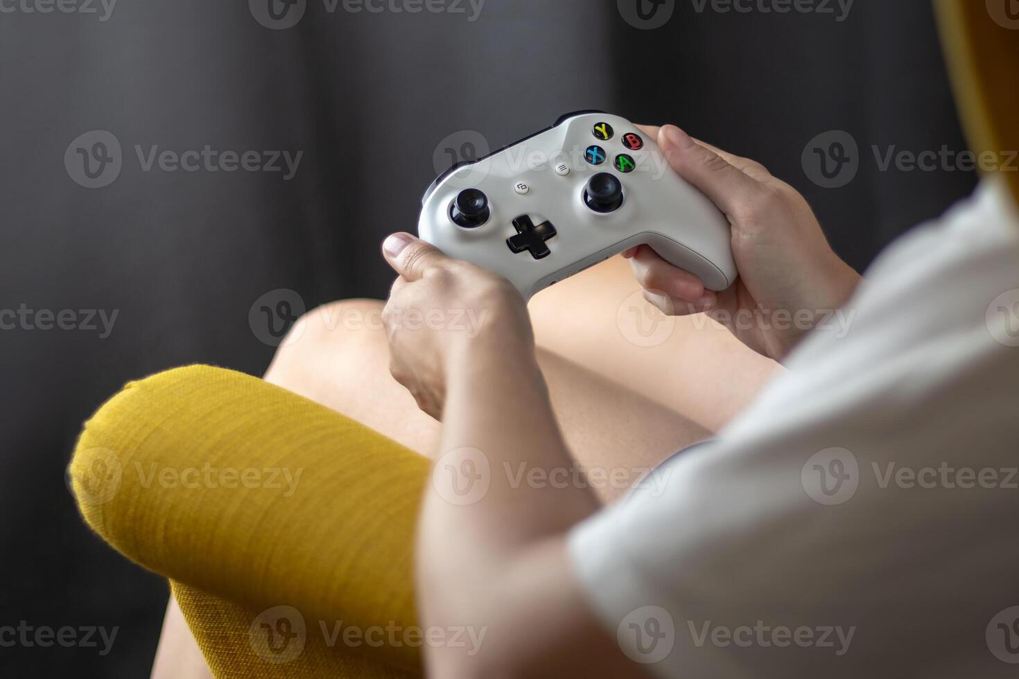 The woman is holding a white jostic, joystick, navigation key, cursor buttons, navigation control. She plays the game on the console. Close up photo