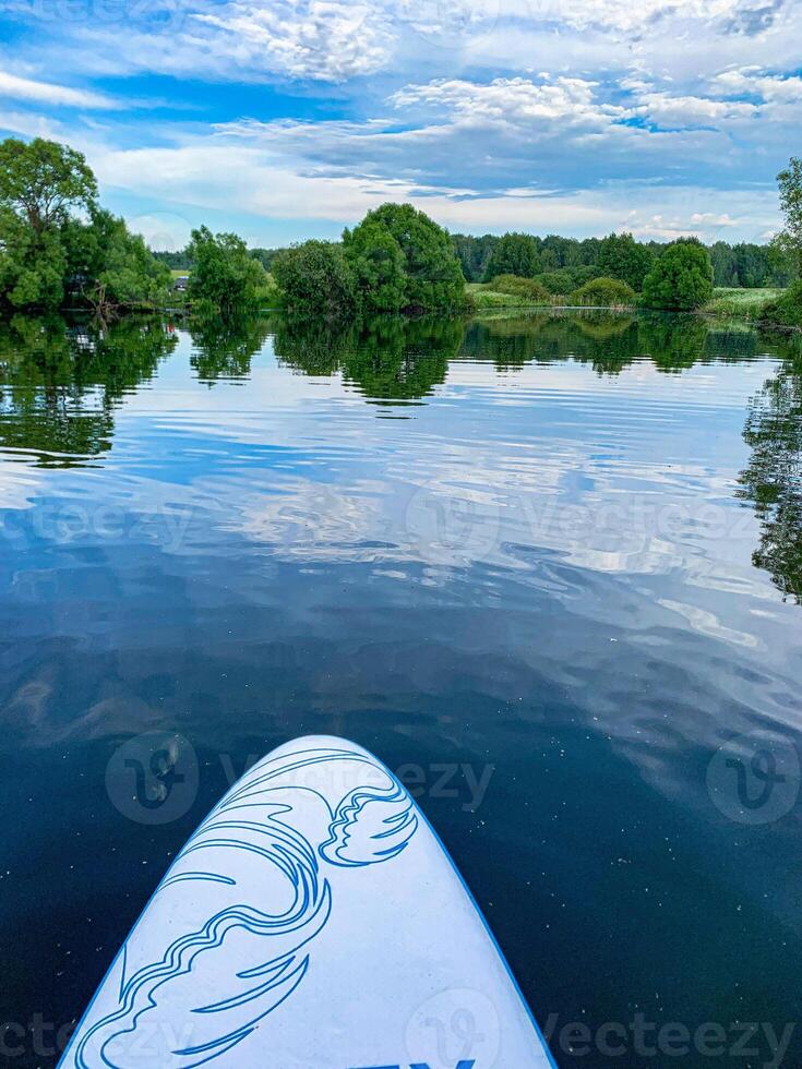 A view of the quiet surface of the lake from a sup board. photo