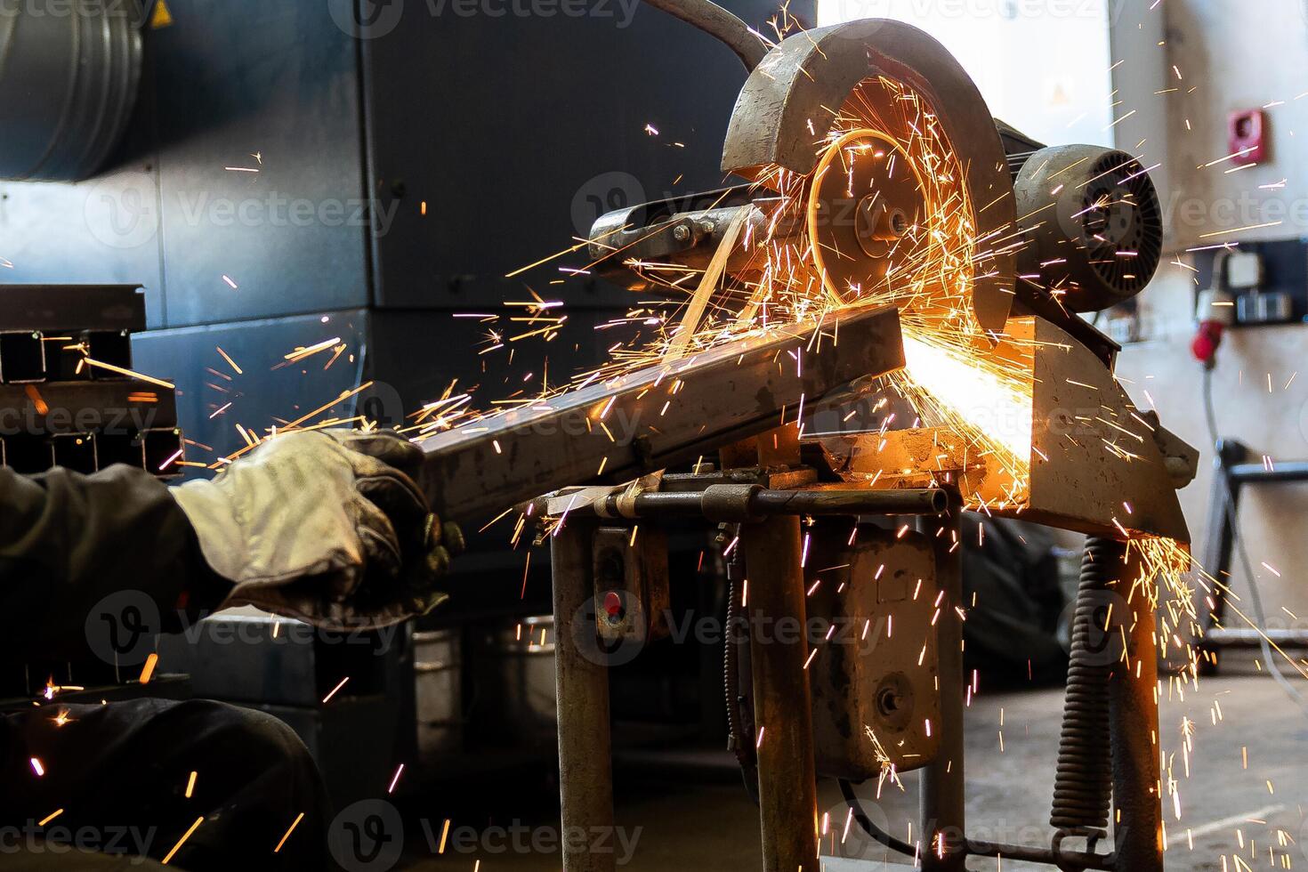 The man is cutting a metal box using cutting machine and the fire sparks splashes outside photo