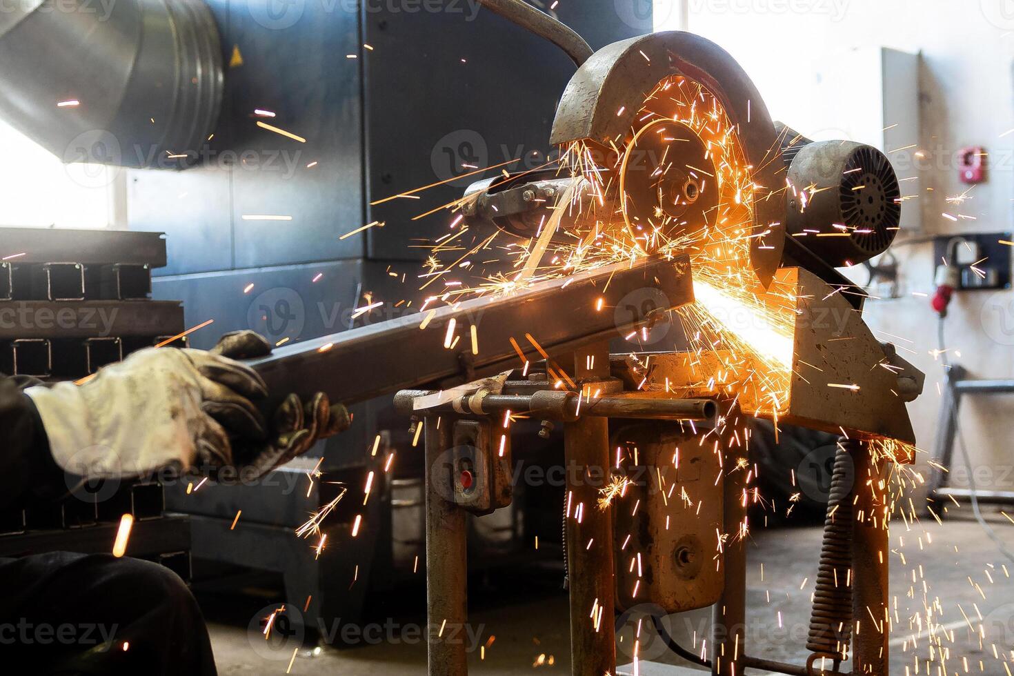 The man is cutting a metal box using cutting machine and the fire sparks splashes outside photo