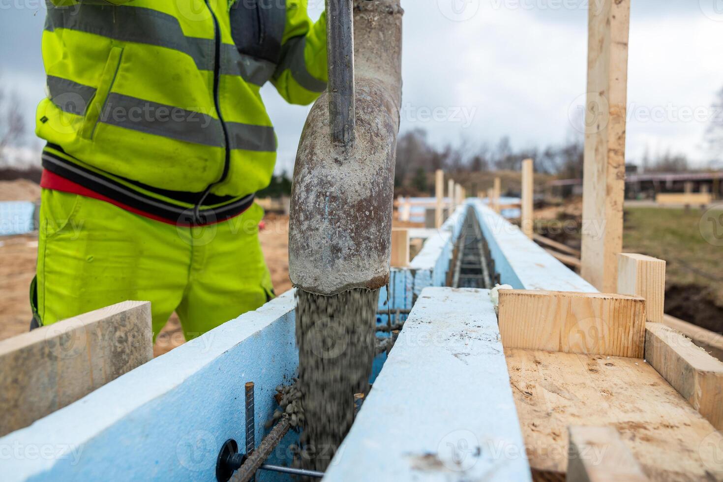 Construction Worker Precisely Operating Concrete Pump at New Building Site Foundations photo