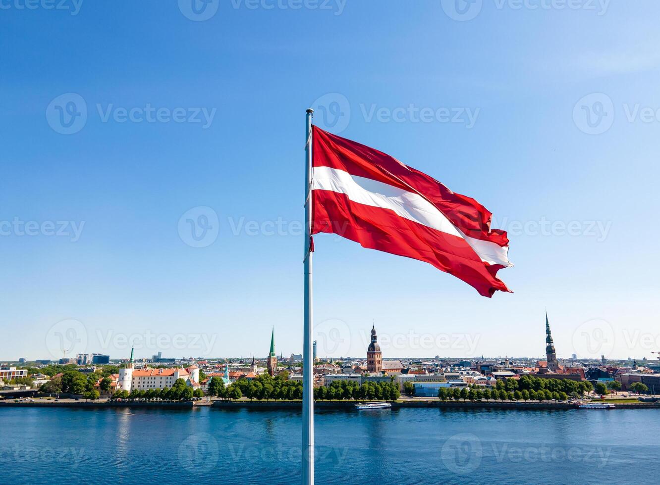 Huge Latvian flag flutters in the wind with Riga old town in the background in Latvia Beautiful summer day photo