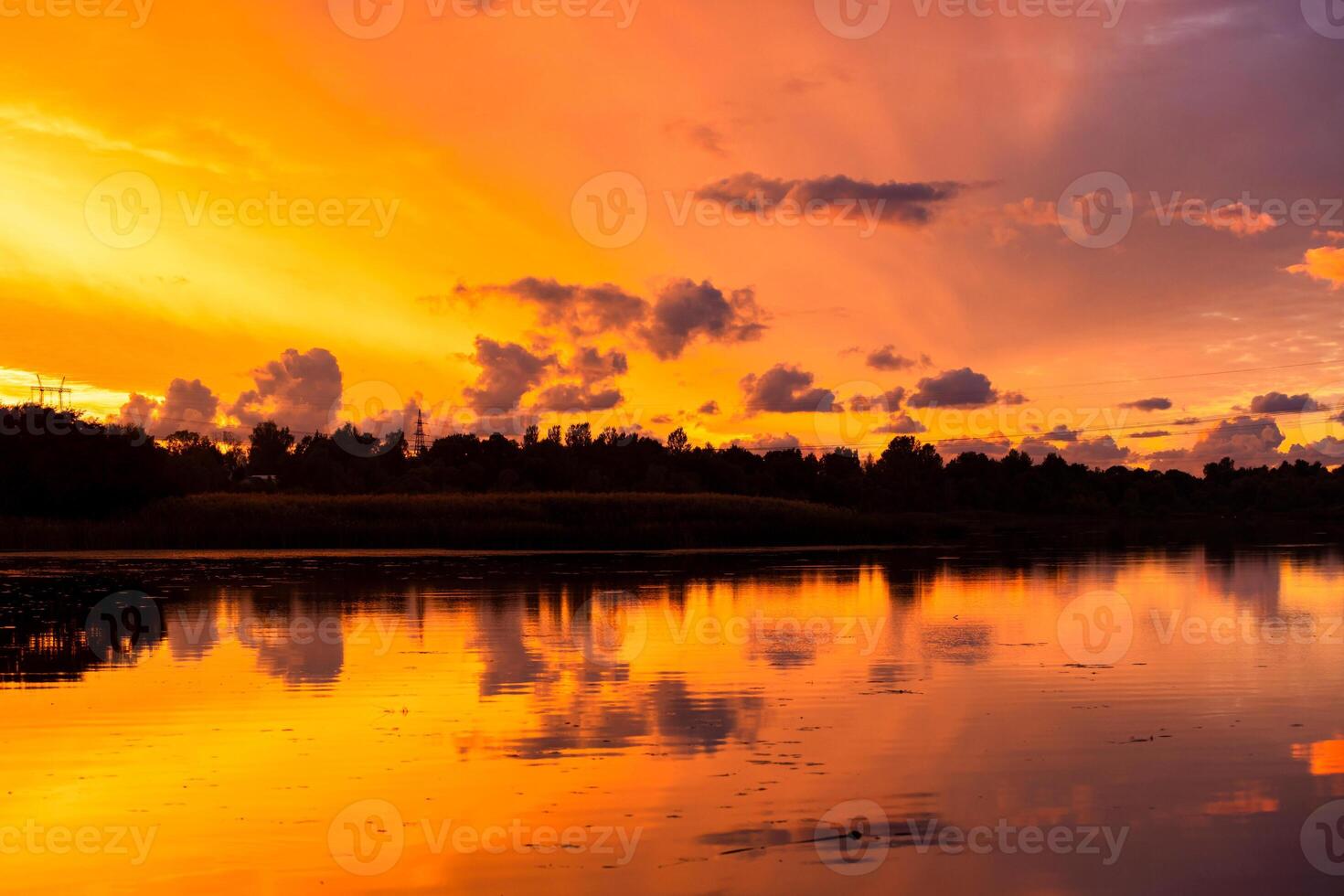 Amazing sunrise in rural scene Symmetry of the sky in a lake at sunset Clouds reflecting on the water Quiet relaxing scene with a beautiful colorful cumulonimbus photo
