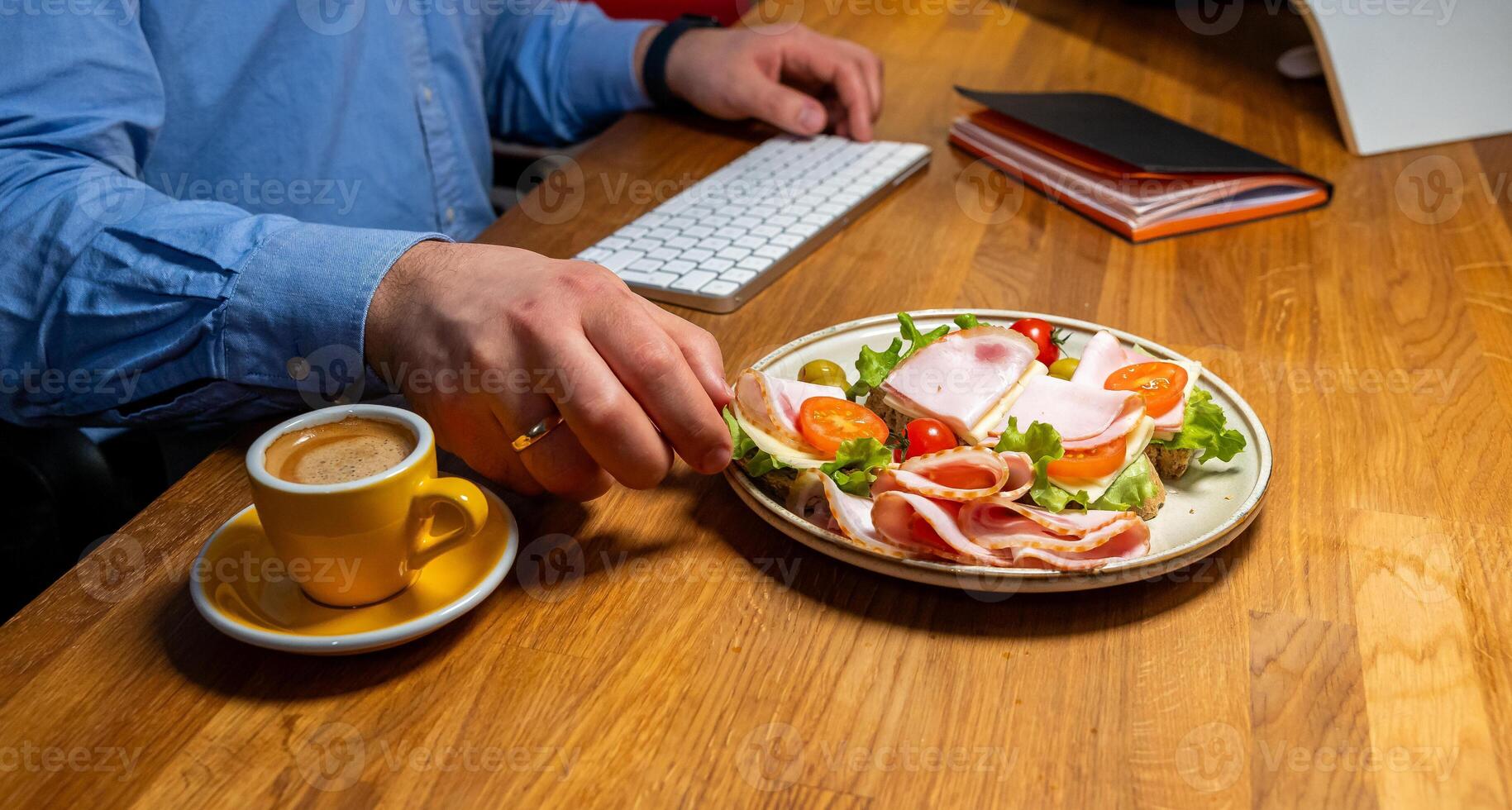 Businessman enjoying a healthy meal and coffee while working at a modern workspace photo