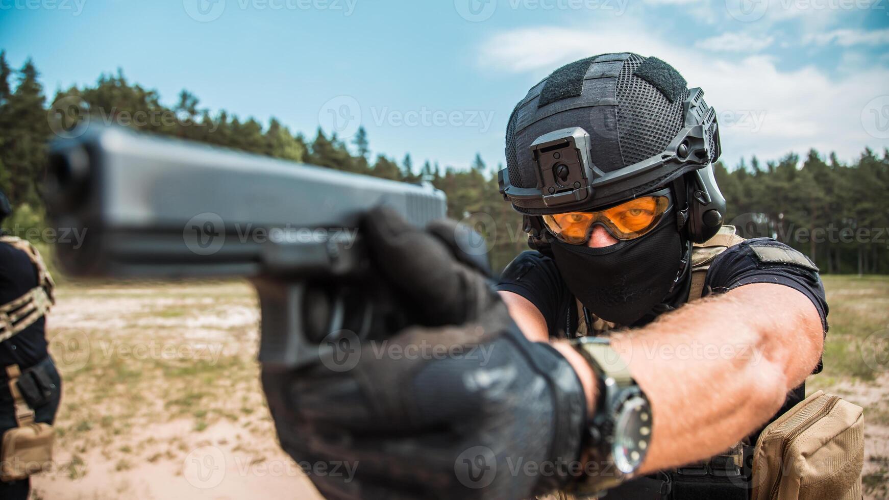 Special forces operatives in tactical gear practicing firearms training at an outdoor shooting range under a cloudy sky photo