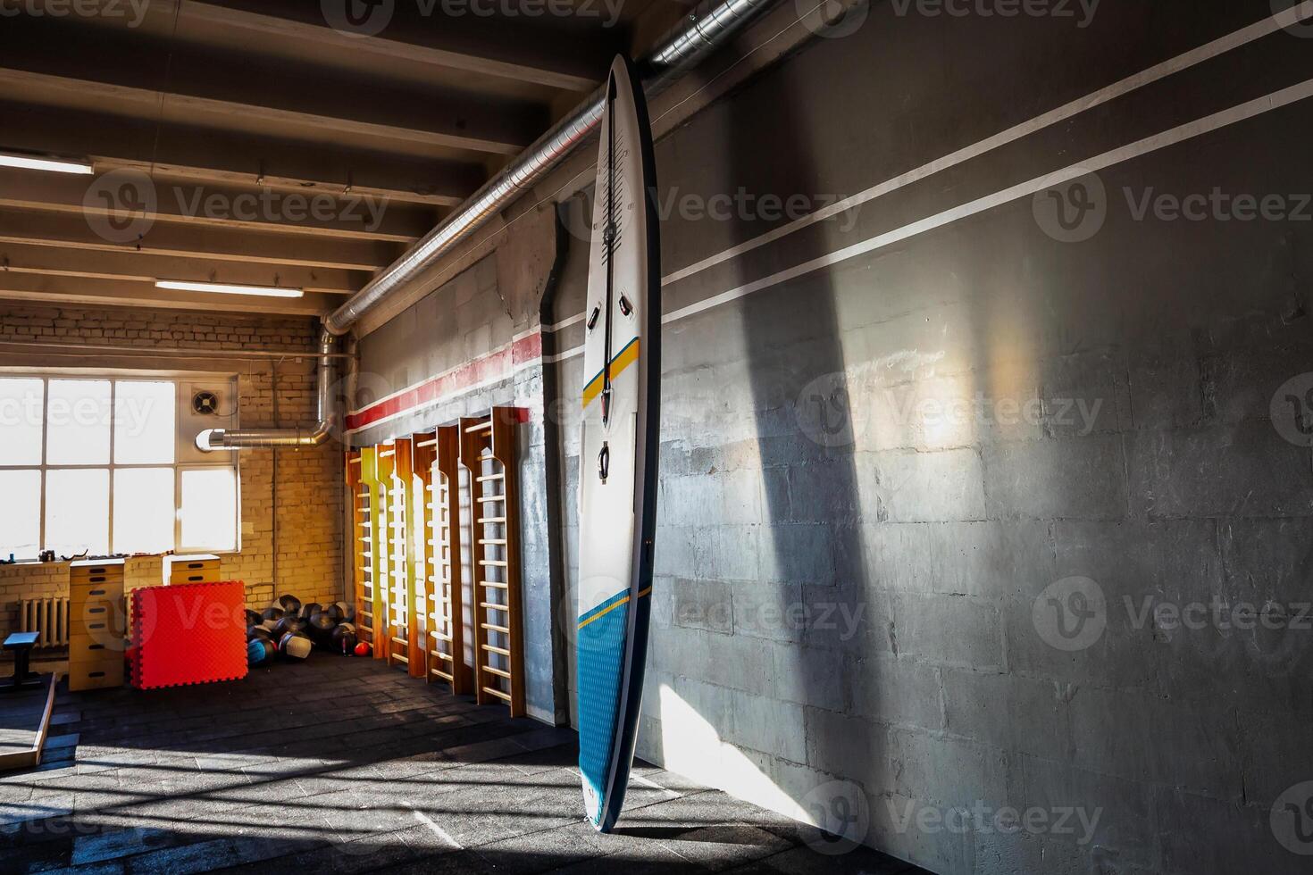 Colorful inflatable stand up paddle board SUP by the wall Surfing and sup boarding equipment close up photo