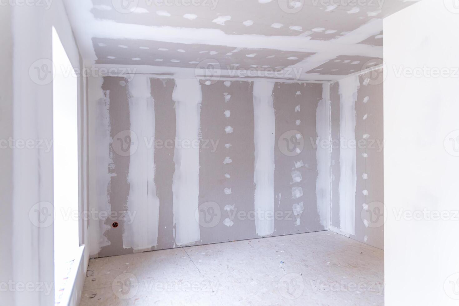 Interior of a house under renovation with drywall installation and joint compound application photo