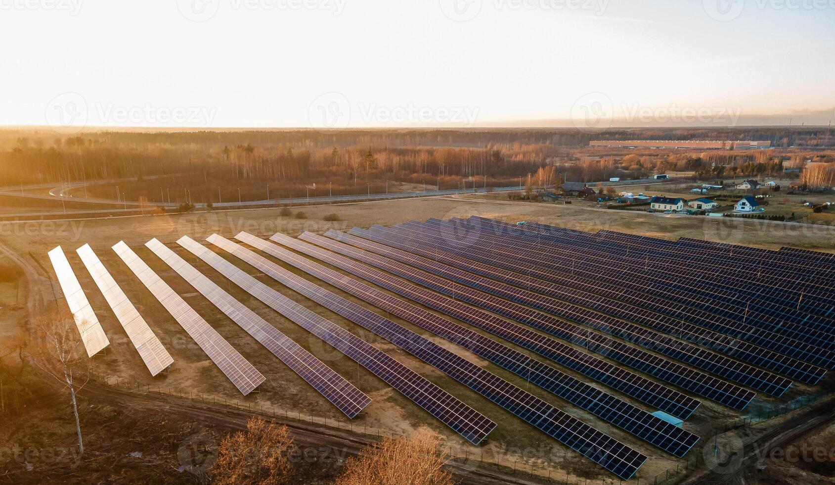 Aerial view of industrial sized solar panel farm during sunset, illustrating the blend of technology and nature photo