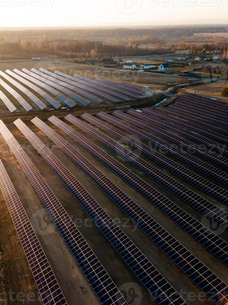 Aerial view of industrial sized solar panel farm during sunset, illustrating the blend of technology and nature photo