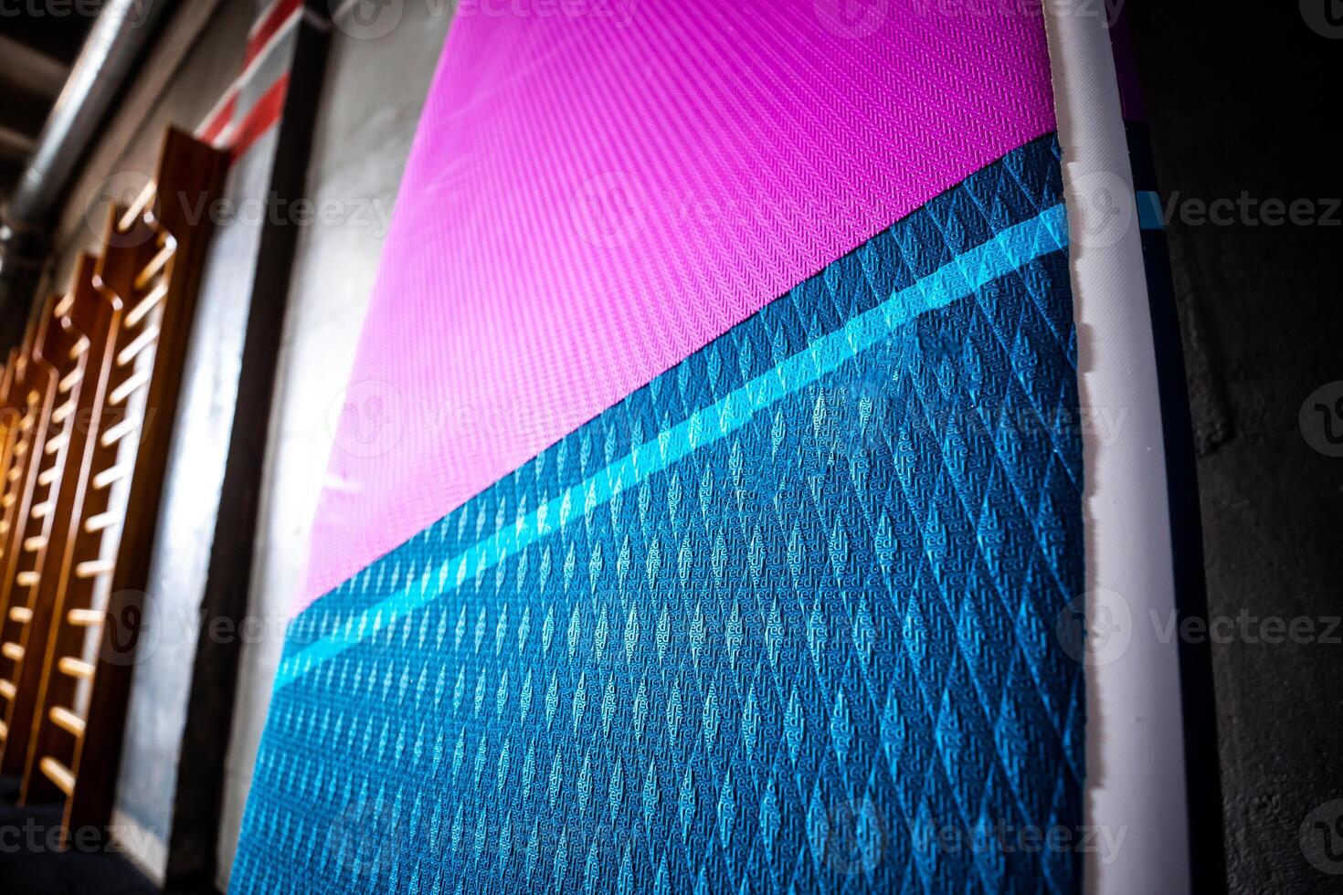 Blue and pink stand up paddle boards SUP by the wall Surfing and sup boarding equipment close up photo