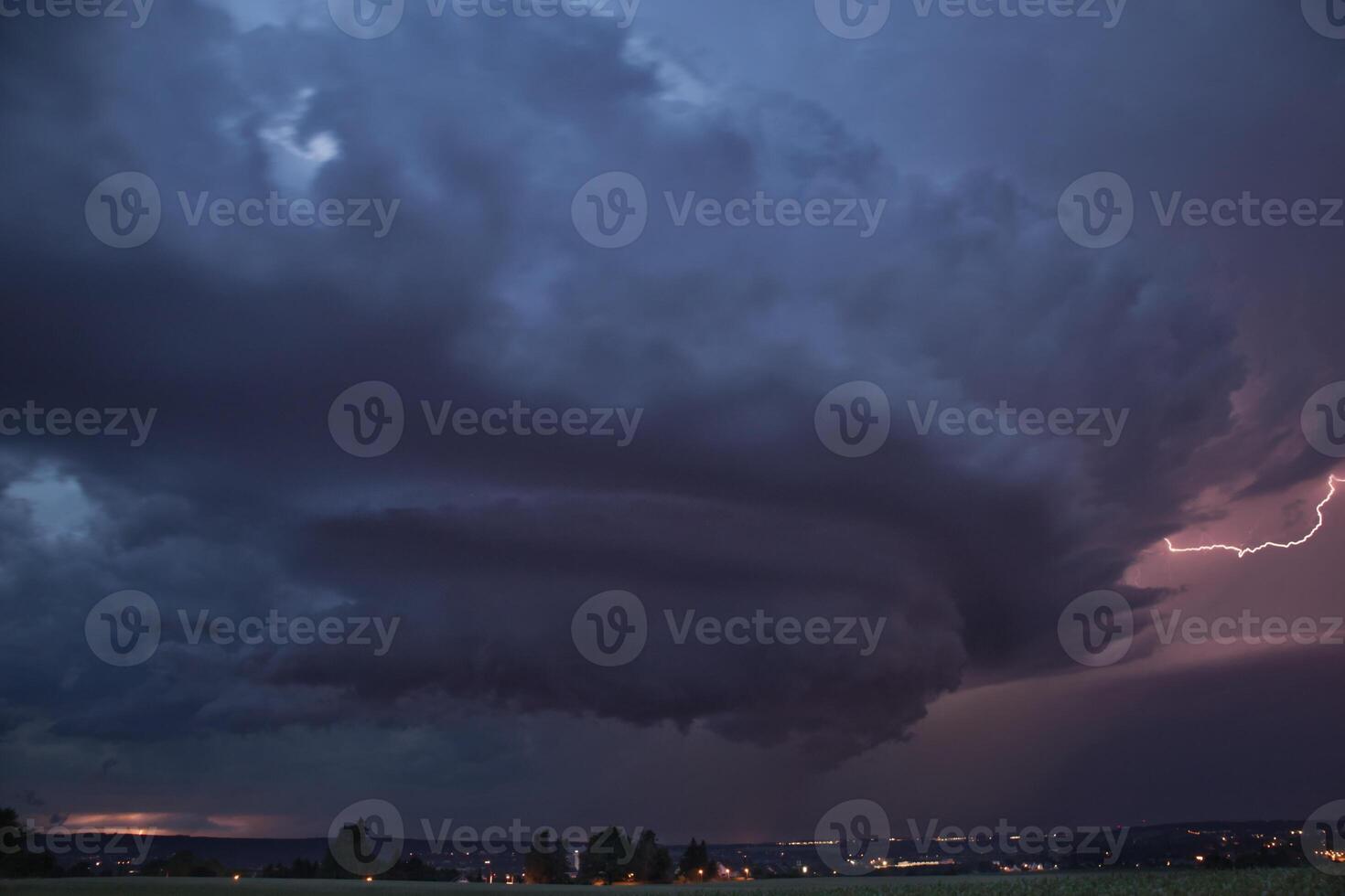 Experience the raw power of nature with this breathtaking image of a supercell storm, showcasing its awe-inspiring structure and dramatic lightning strikes. Captured in stunning detail. photo