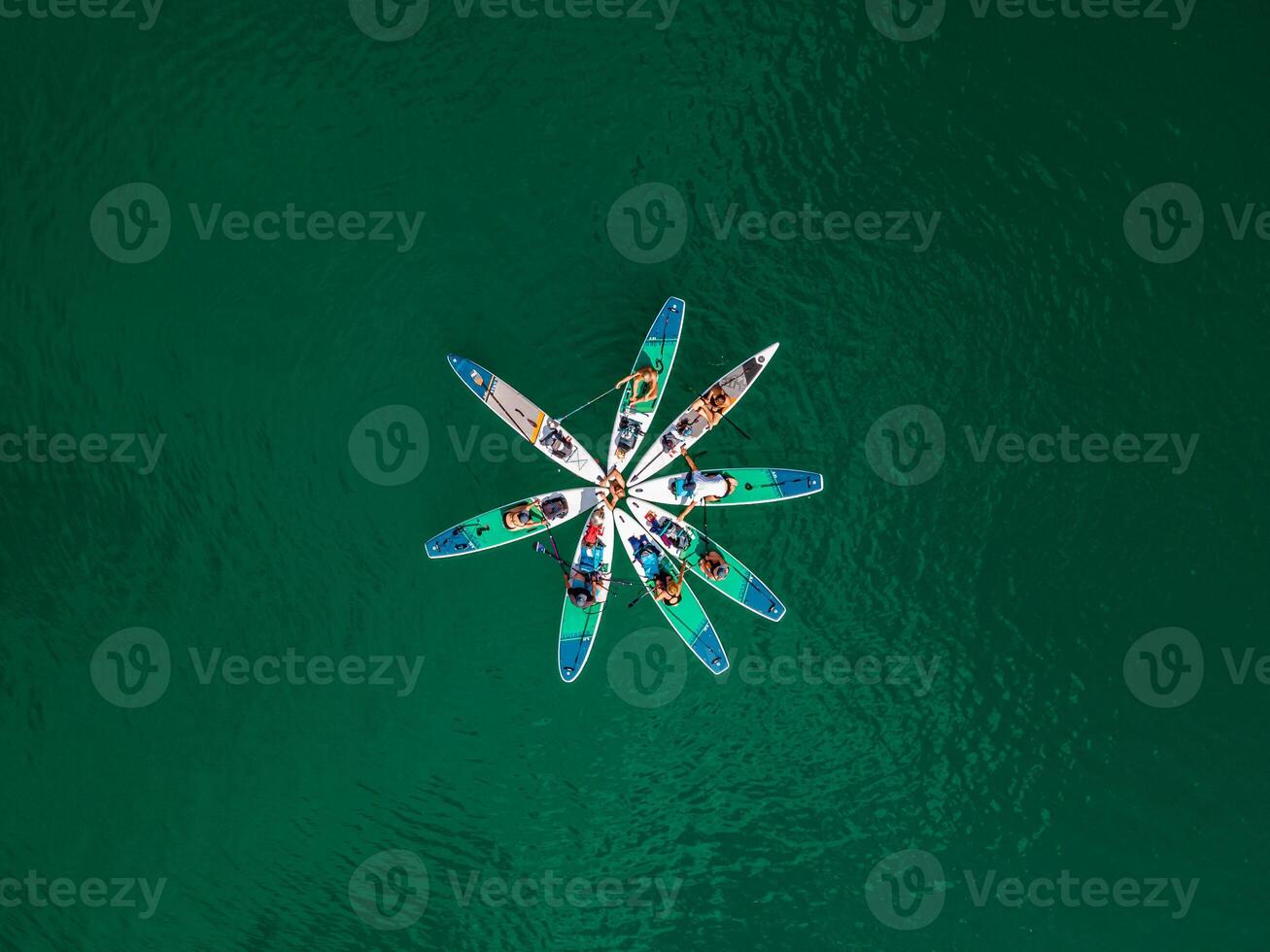 Connecting with Nature Top View of People Holding Hands on SUP Boards after Paddling in a Turquoise Alpine Lake photo