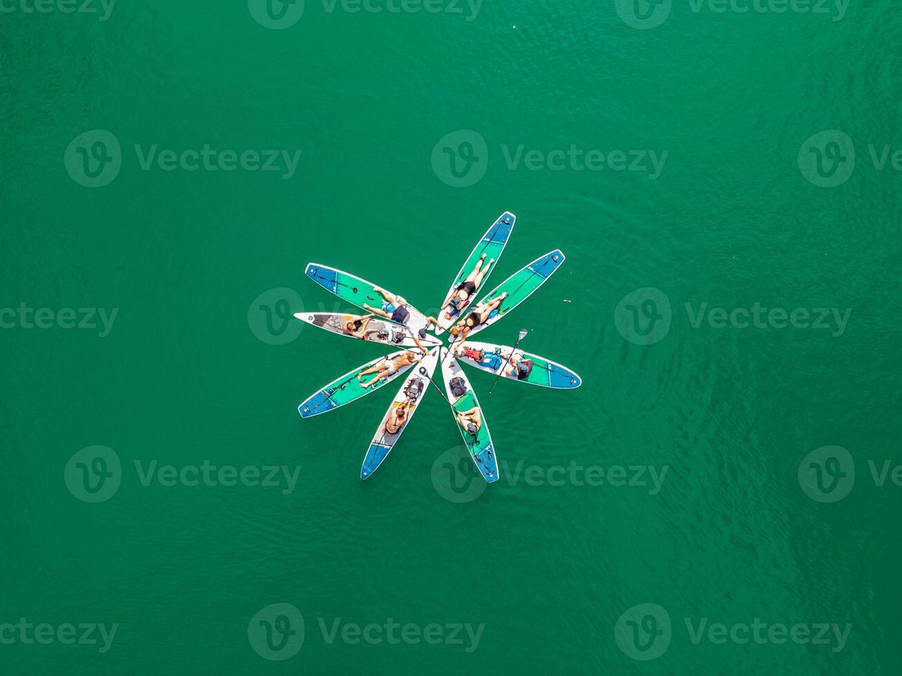 Connecting with Nature Top View of People Holding Hands on SUP Boards after Paddling in a Turquoise Alpine Lake photo