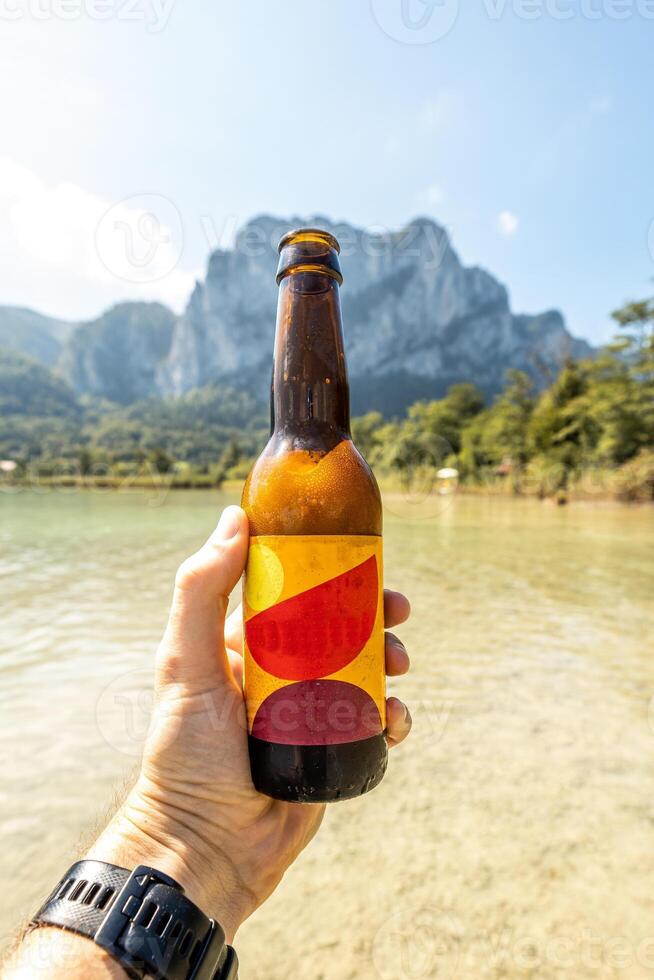 Colorful beer bottle with mountains in the background. Space for text and logo photo