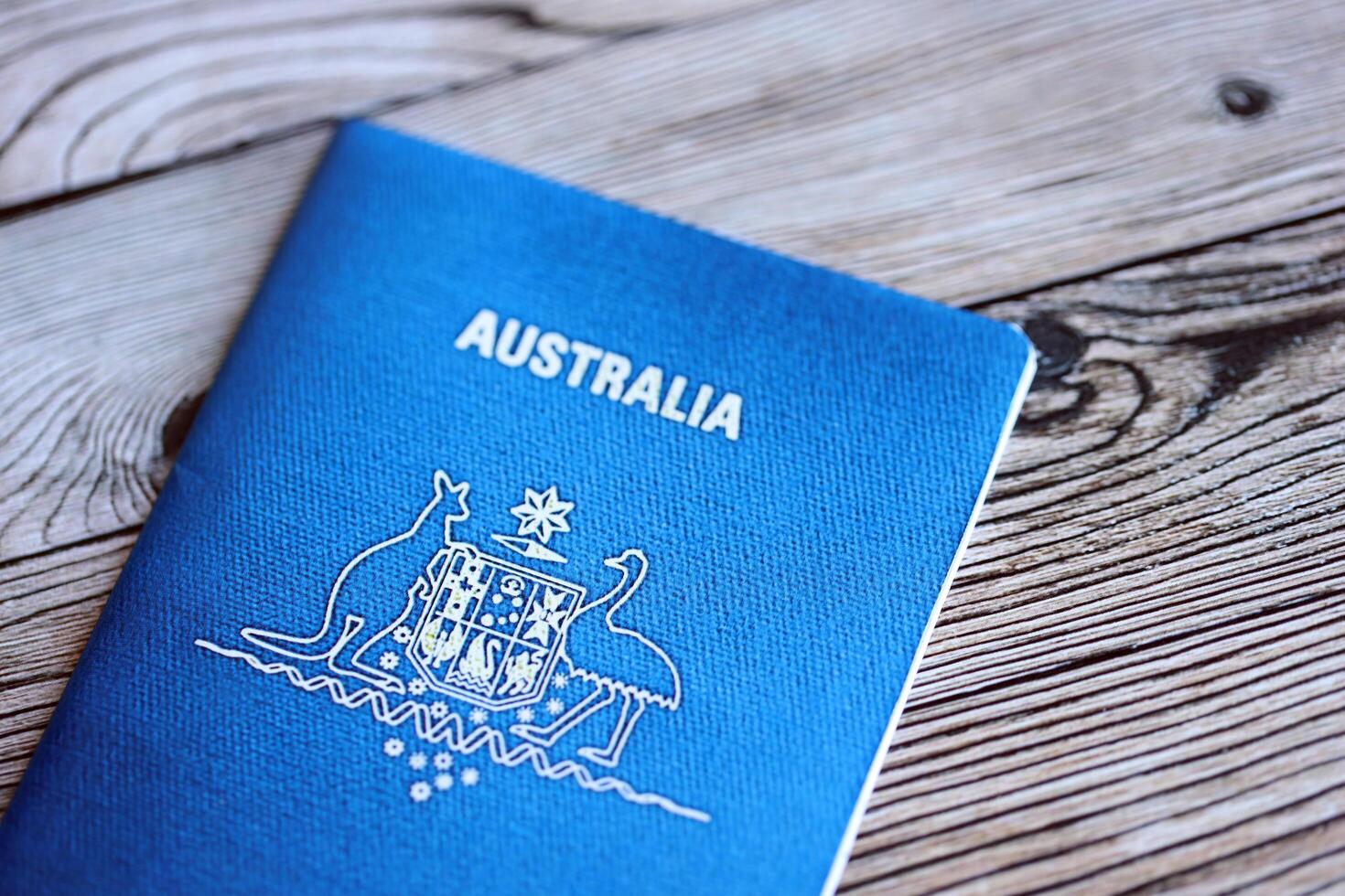 KYIV, UKRAINE - JULY 10, 2024 Australian blue travel passport on wooden background photo