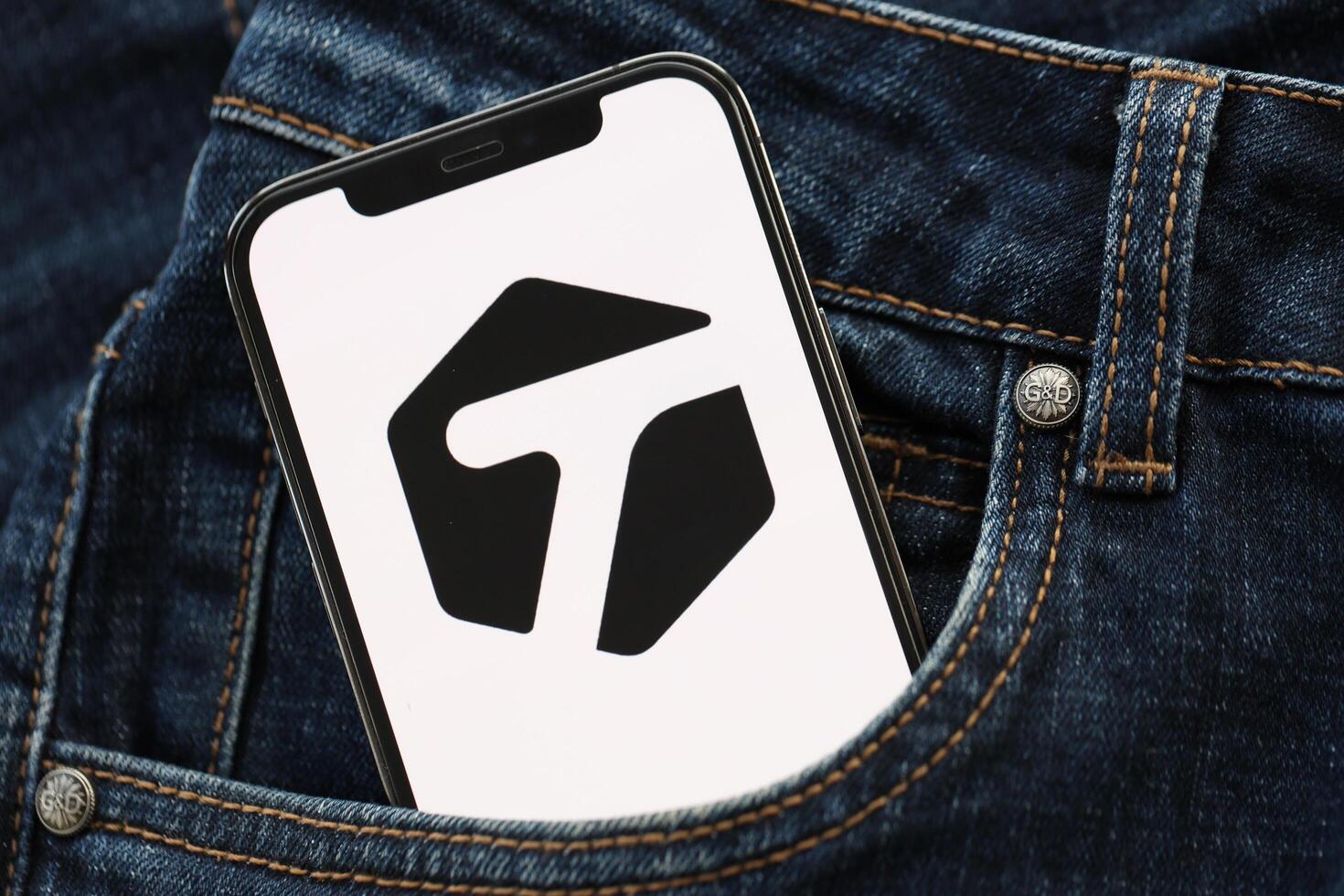 KYIV, UKRAINE - APRIL 1, 2024 Tagged icon on smartphone display screen in jeans pocket photo