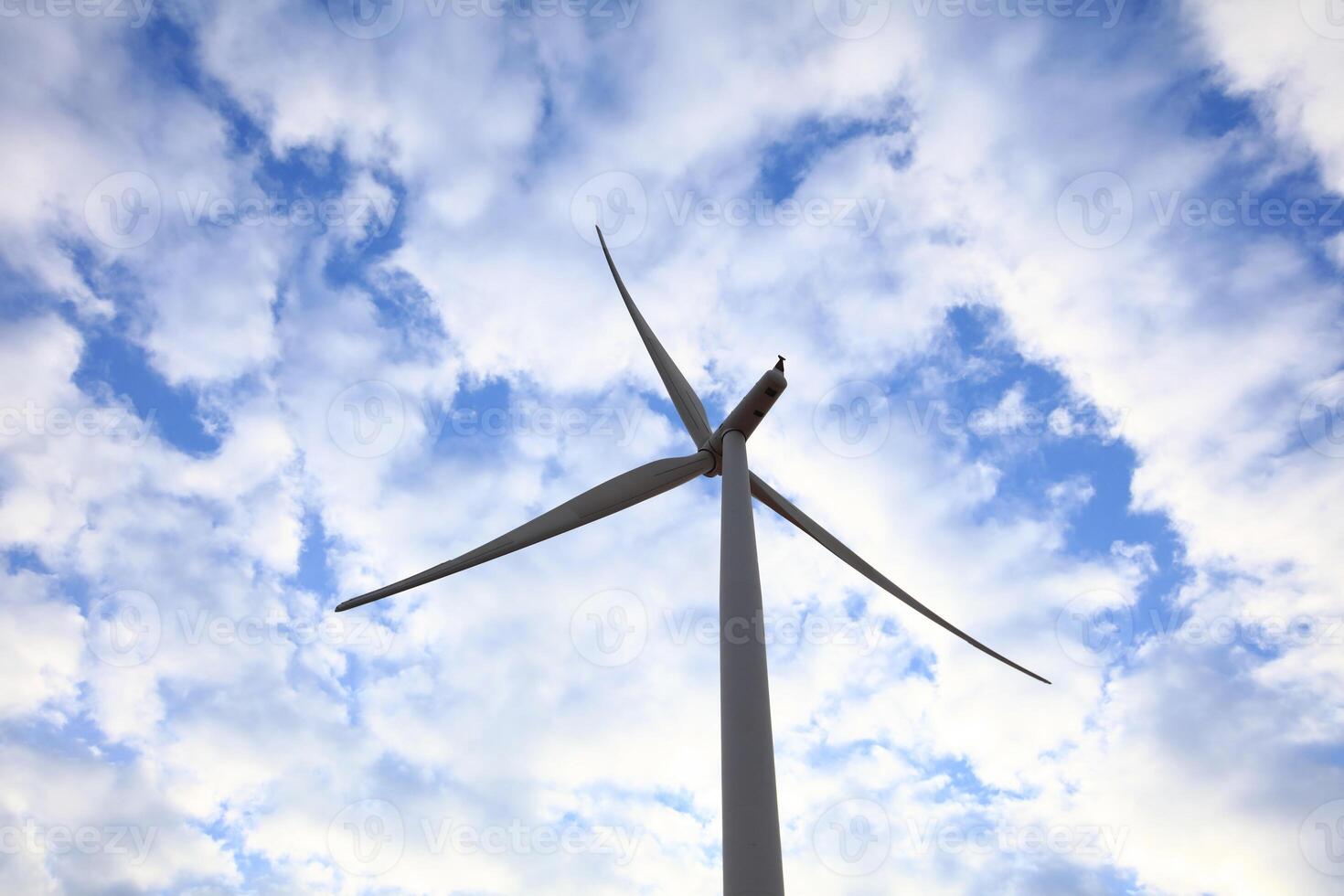 the propeller of wind turbine against the blue sky and cloudy in background photo