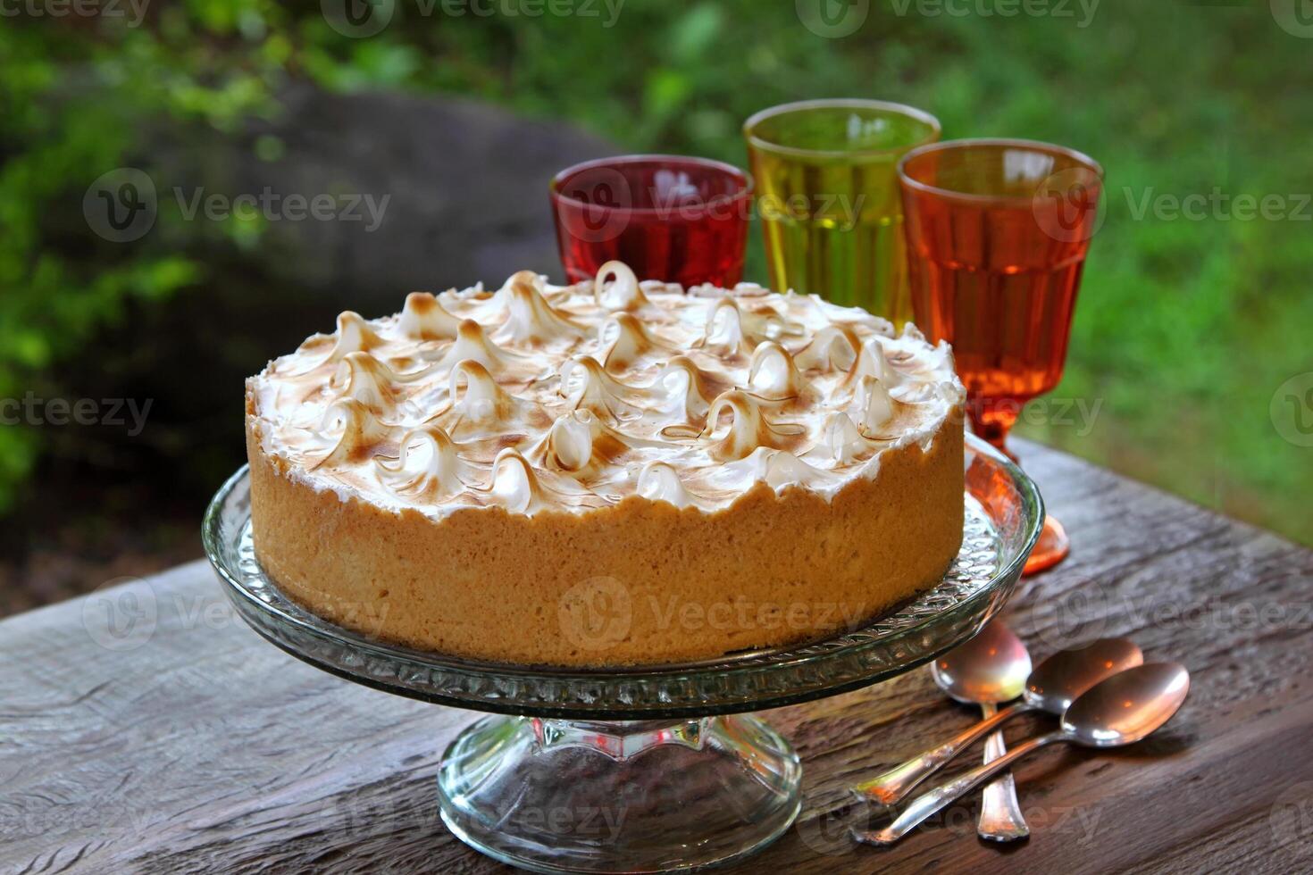 Lemon pie with spoons and glasses on wooden table photo