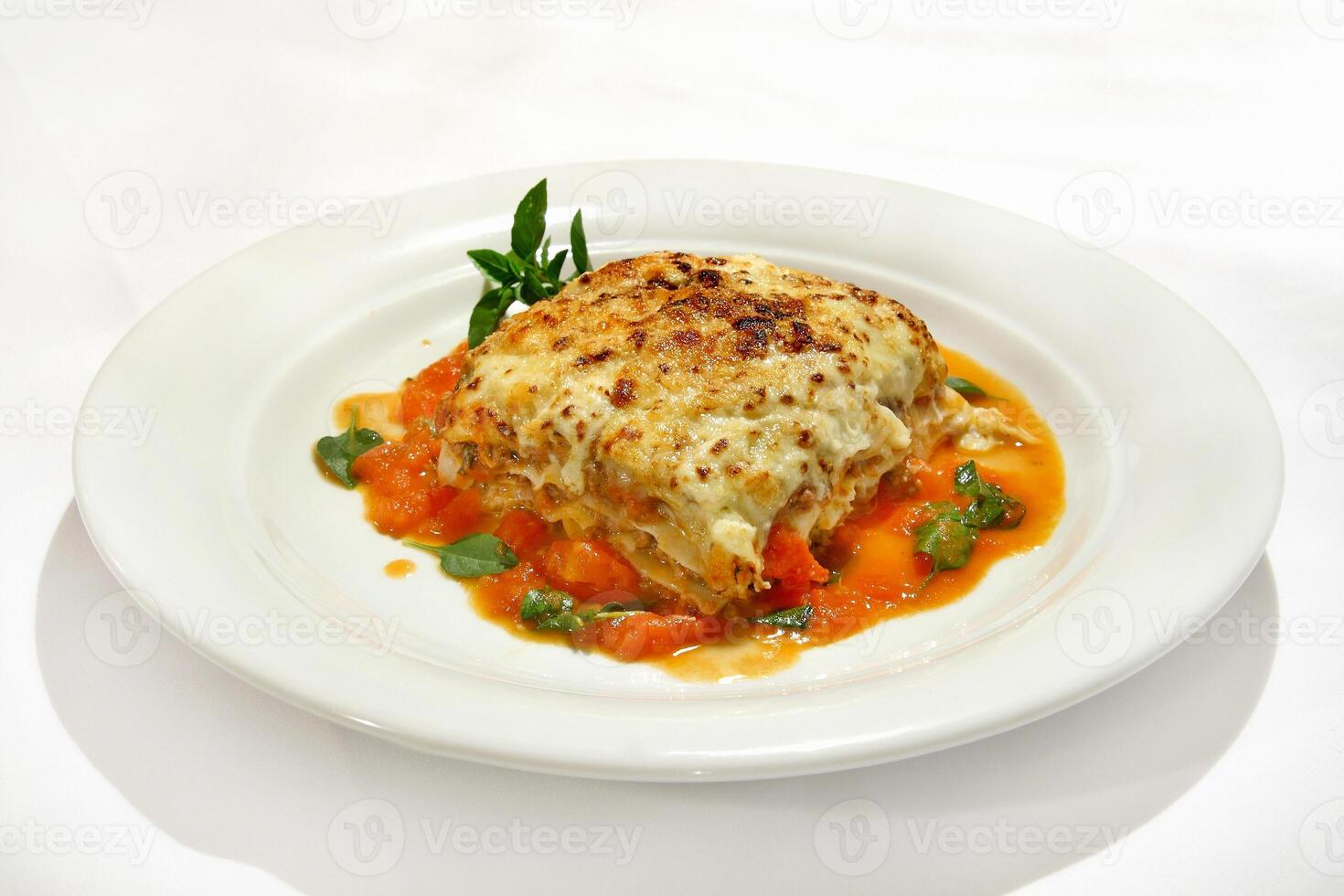 Bolognese lasagna with basil on plate photo