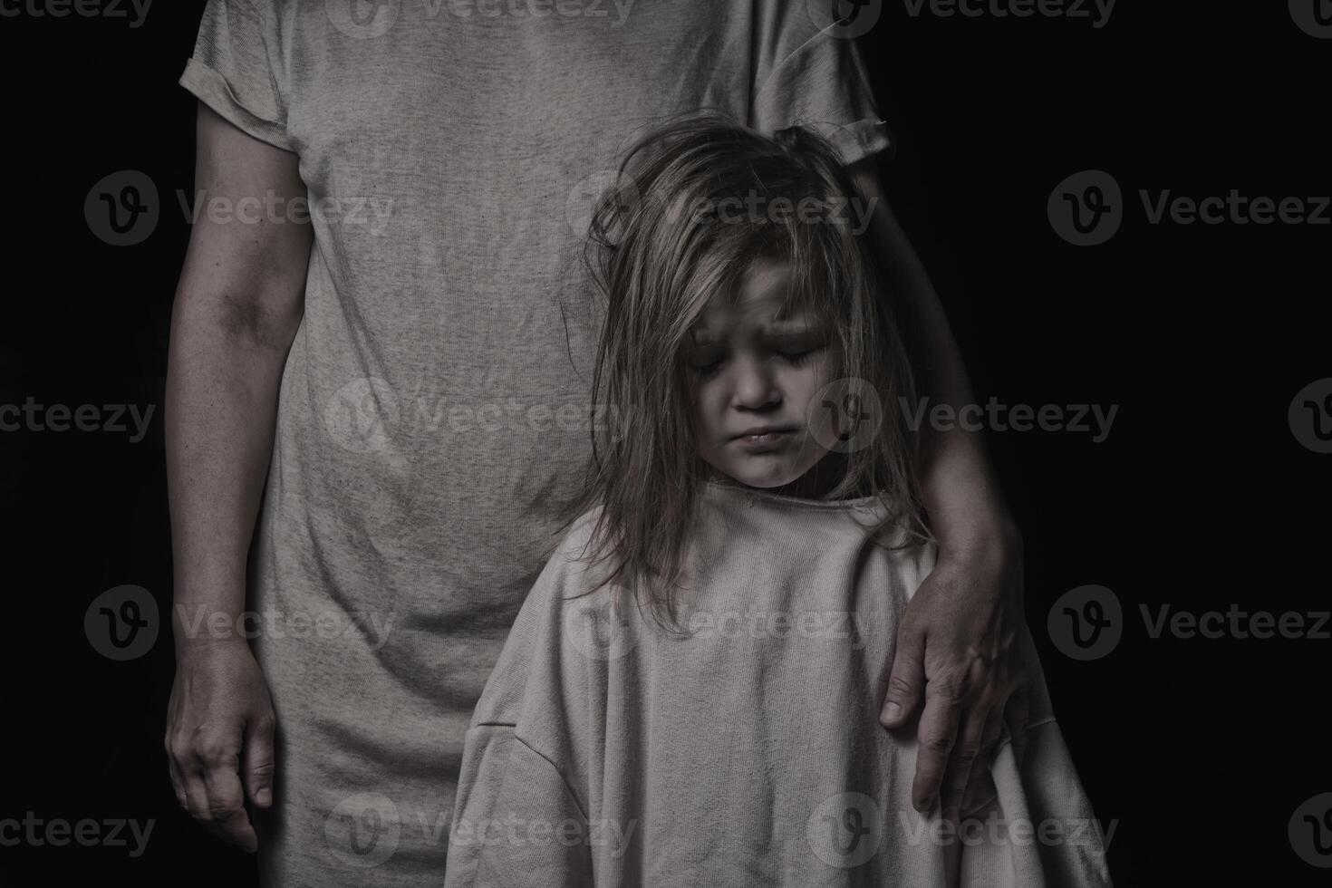 little daughter and mother are sad on a black background photo